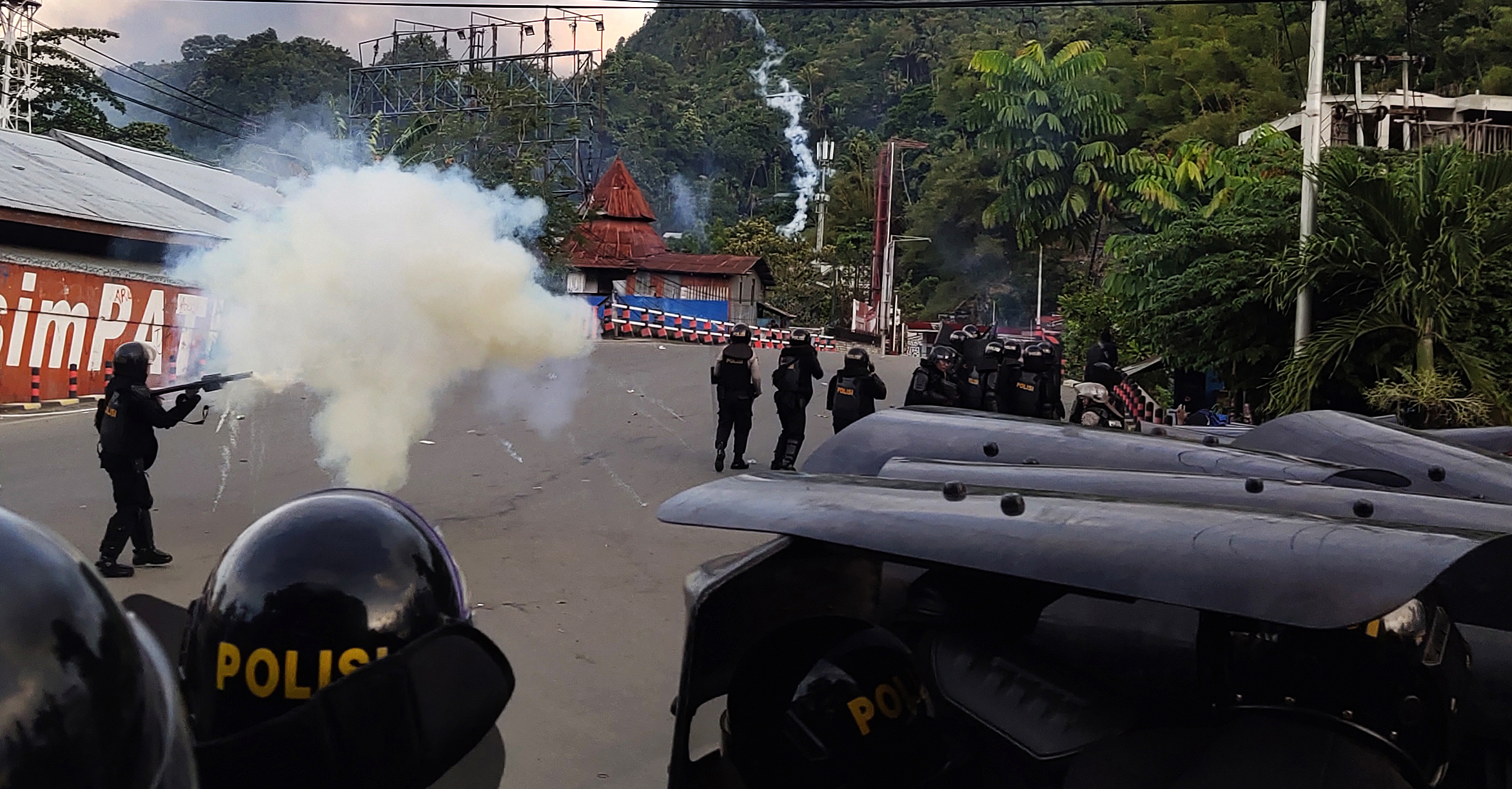 etugas kepolisian melepaskan tembakan gas air mata untuk menghalau massa saat berlangsungnya aksi unjuk rasa di Jayapura, Papua, Kamis(29/8)