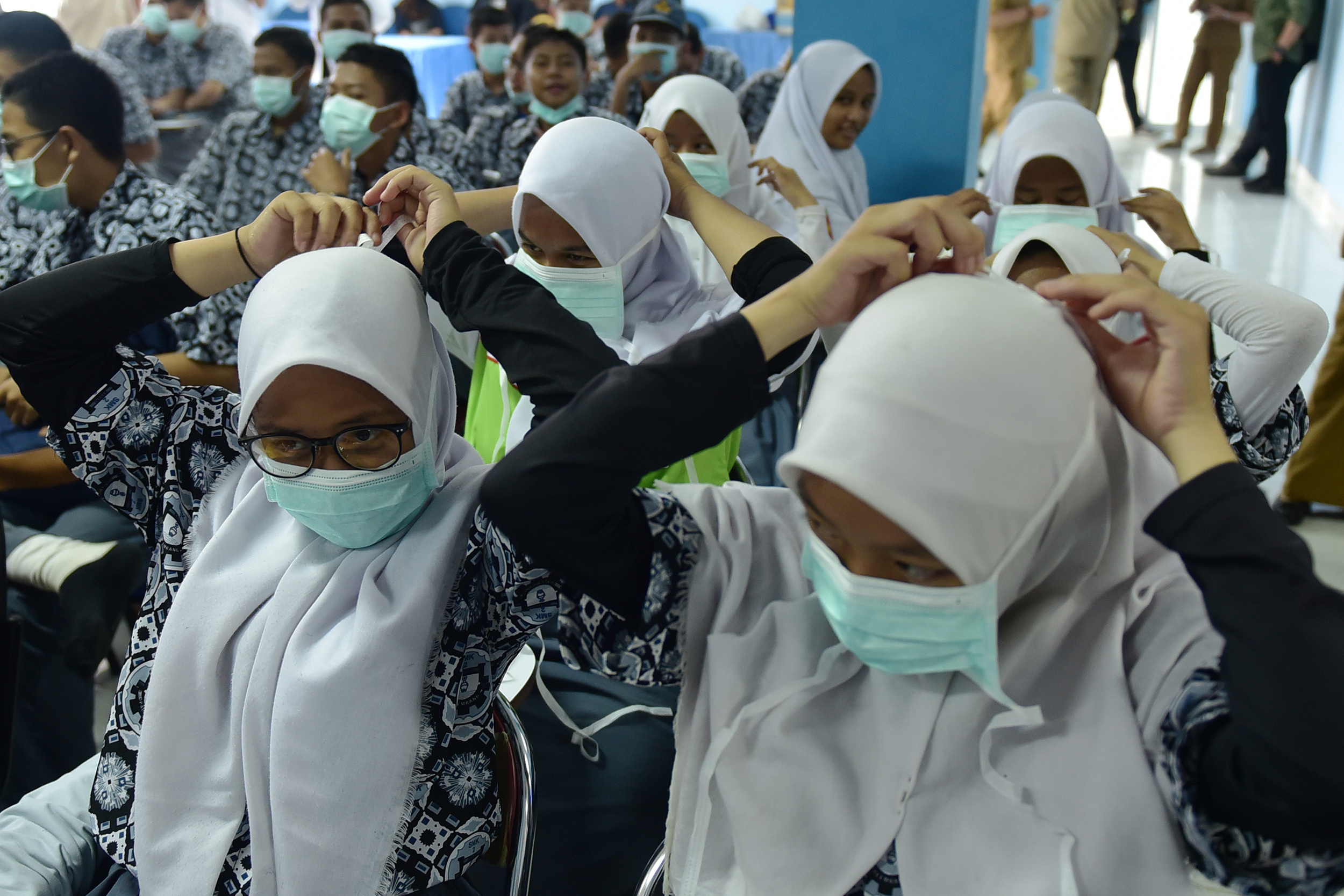  Siswa SMKN 2 Palembang memasang masker yang dibagikan Dinas Kesehatan Sumsel saat sosialisasi bahaya kabut asap.