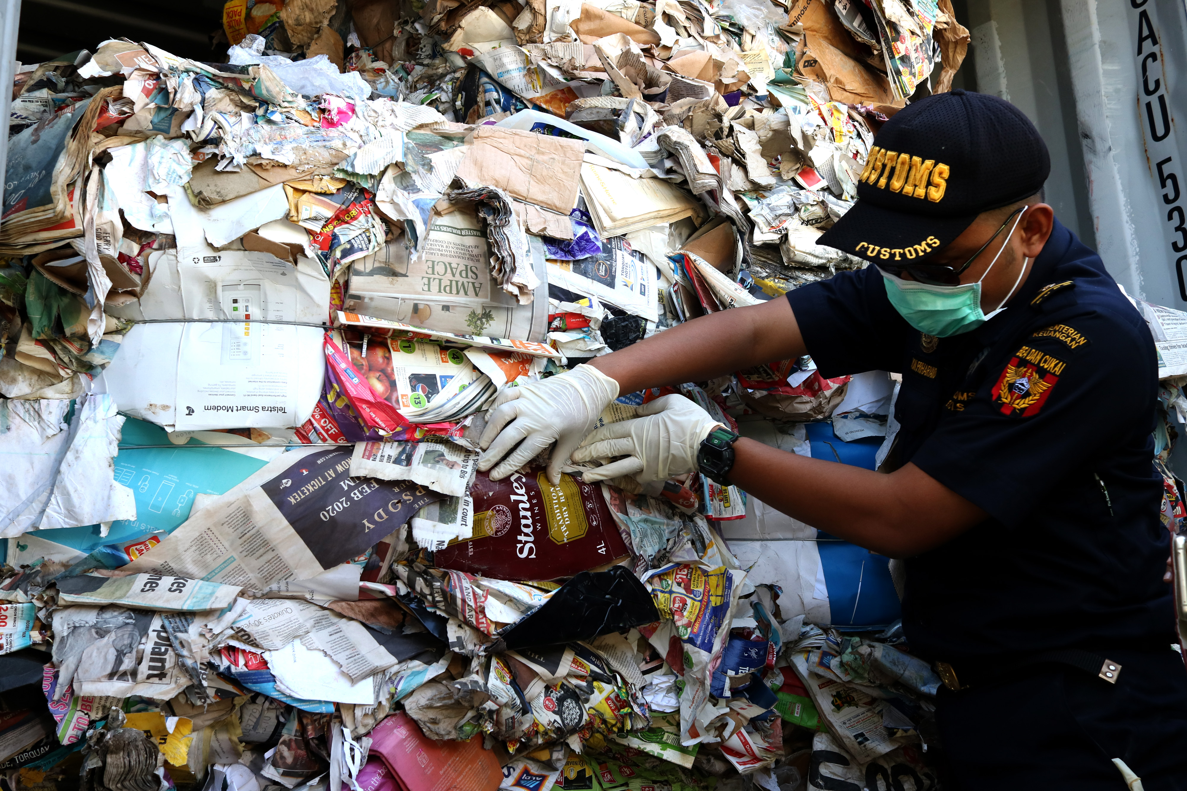 Petugas menunjukkan kertas bekas impor yang dikirim dari Australia di Terminal Peti Kemas Surabaya (TPS) di Surabaya, Jatim, Selasa (9/7)