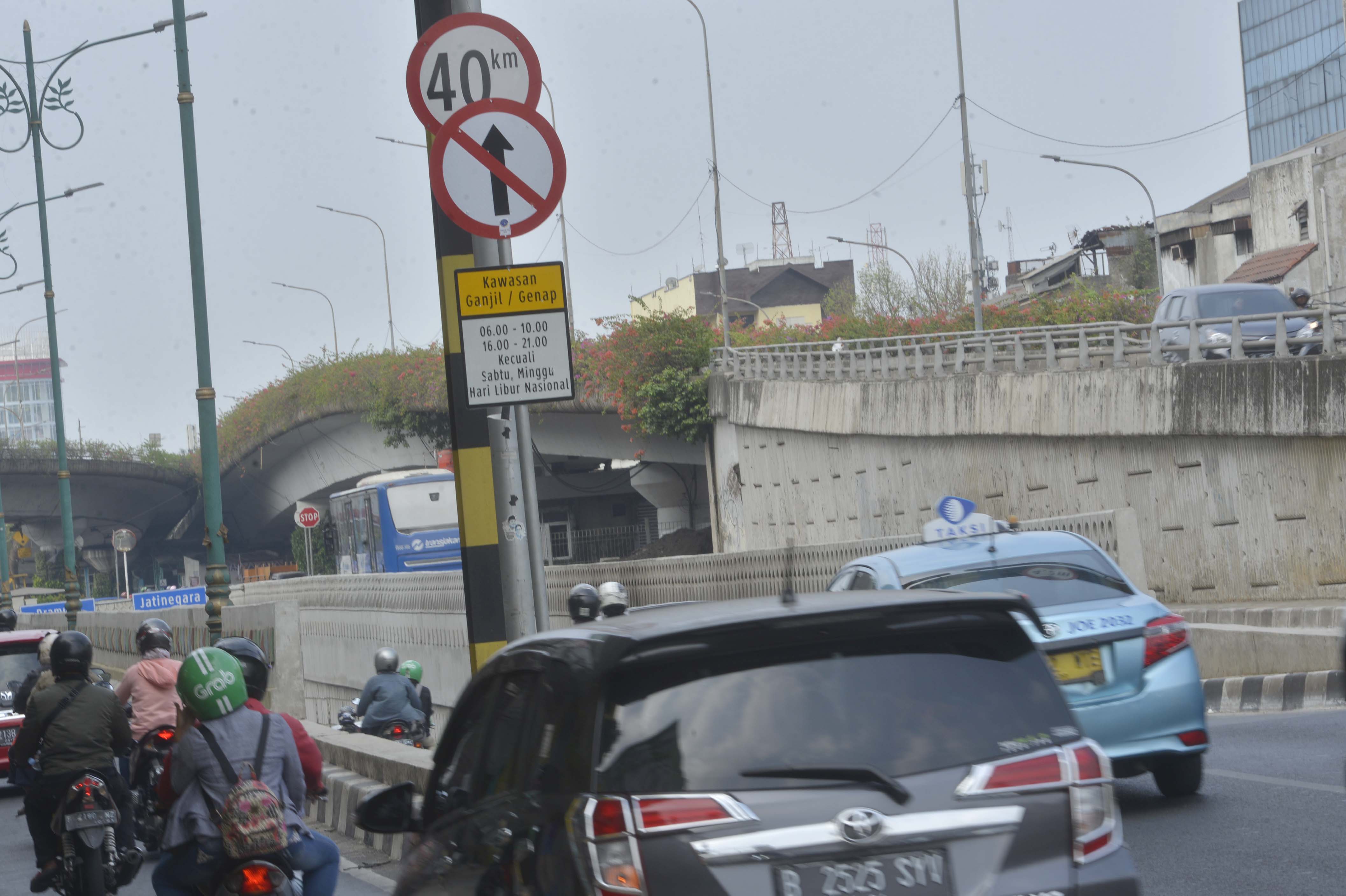  Sebuah papan rambu lalu lintas penerapan Kawasan ganjil genap terpasang pada jalur masuk Under Pass di Matraman, Jakarta Pusat, Minggu (8/9