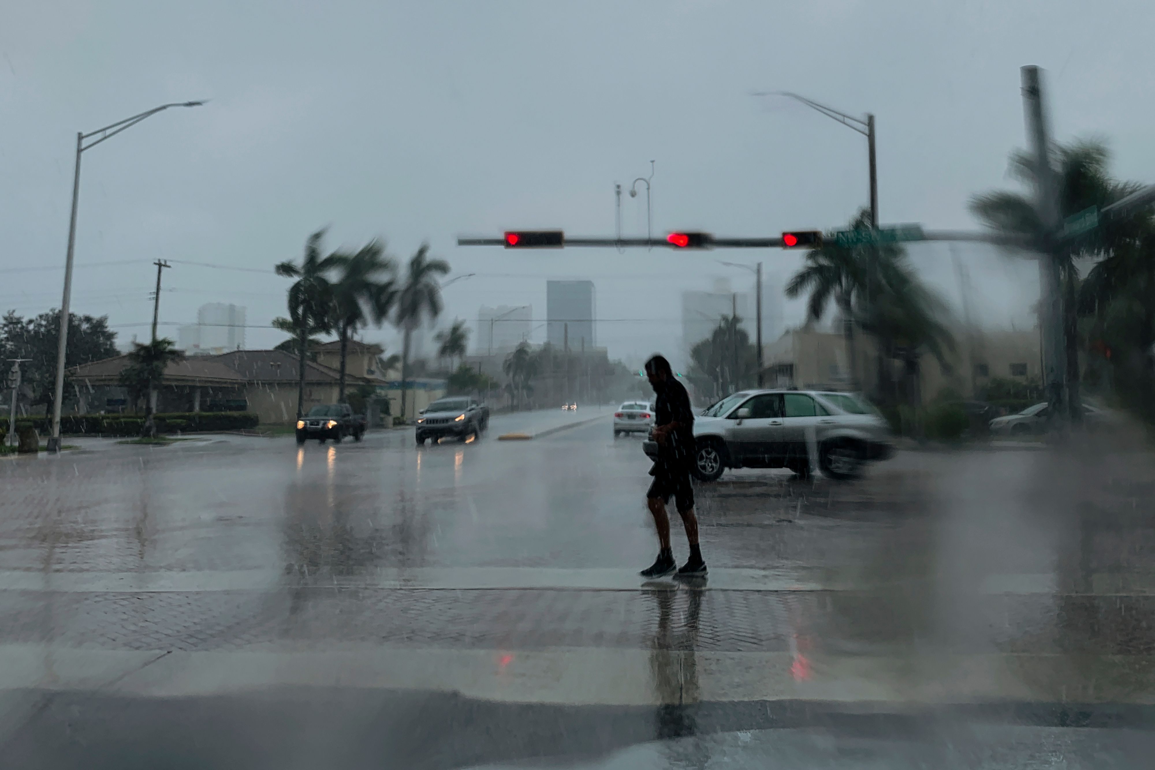 Seorang pria menyeberang jalan di tengah hujan di Fort Lauderdale, Florida. Badai Dorian telah mendarat di Bahama.