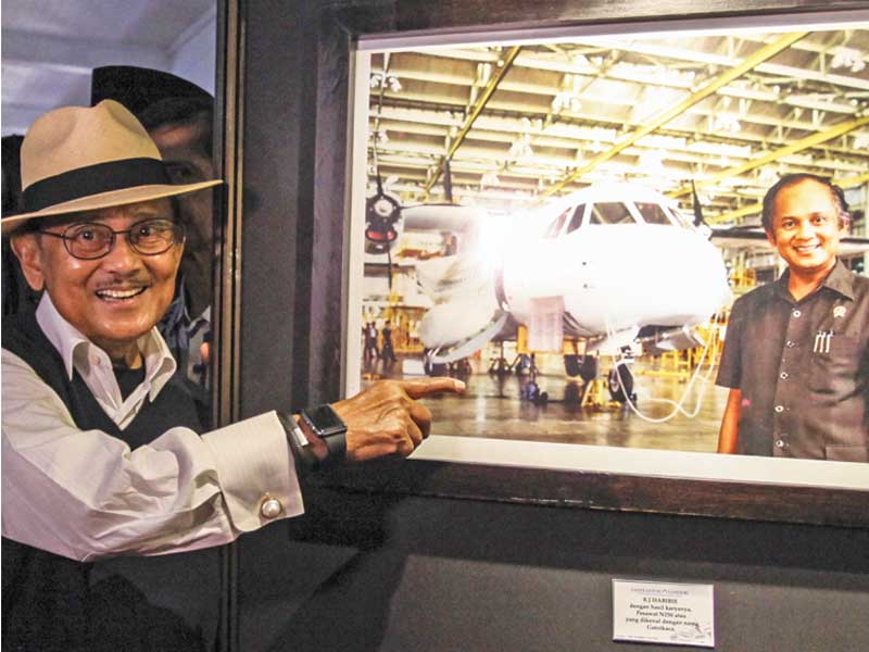 Mantan Presiden BJ Habibie menunjukkan foto dirinya bersama pesawat hasil karyanya N-250 Gatotkaca.
