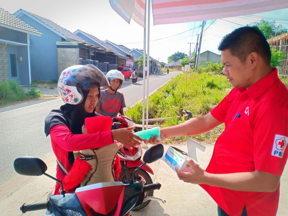 Petugas Satgas Kekeringan membagikan masker kepada para pengendara motor di Bangka Belitung. Rabu (11/9).