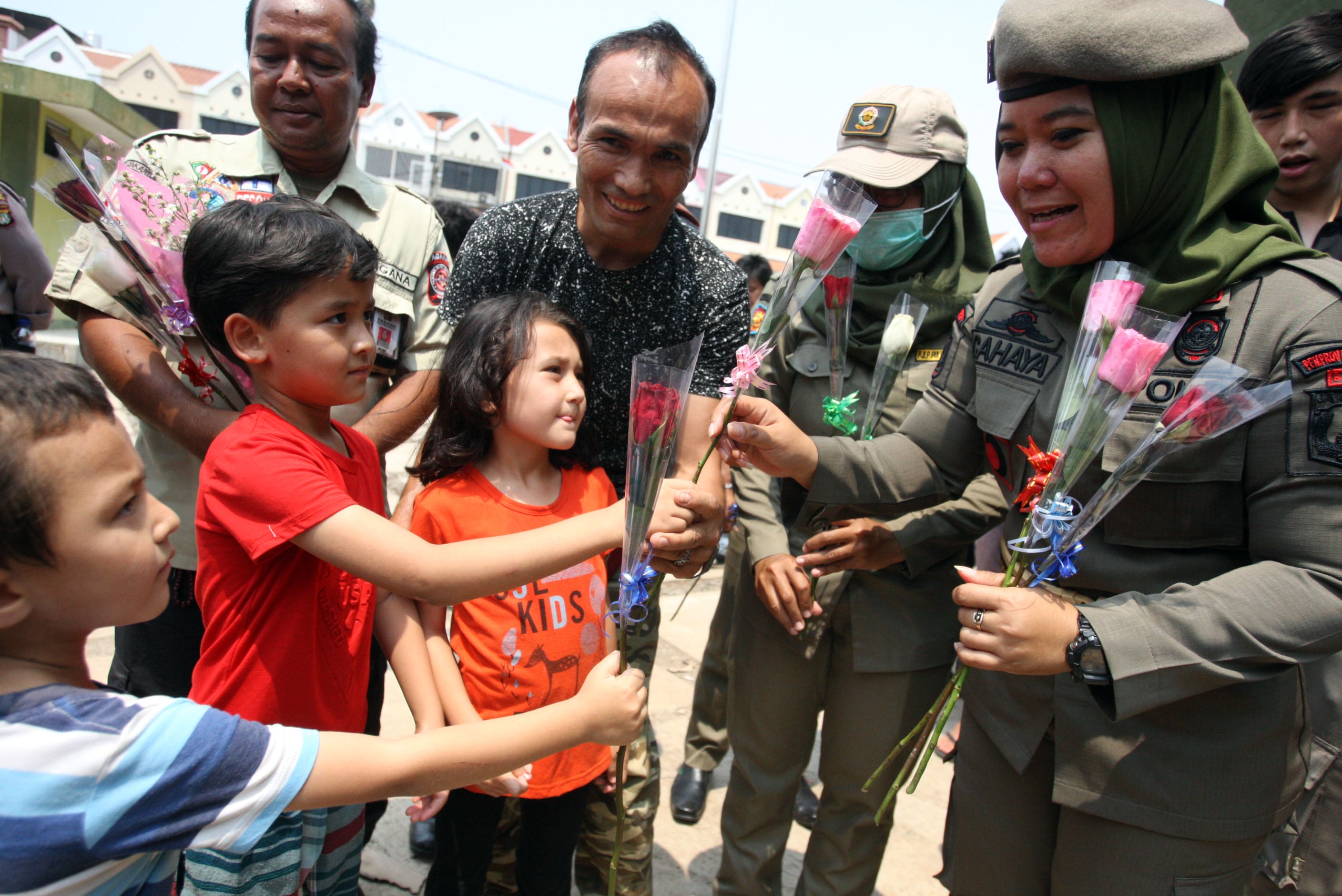 Anak-anak pencari suaka memberikan bunga kepada petugas dan warga Indonesia sebagai ucapan terima kasih di tempat Penampungan Sementara