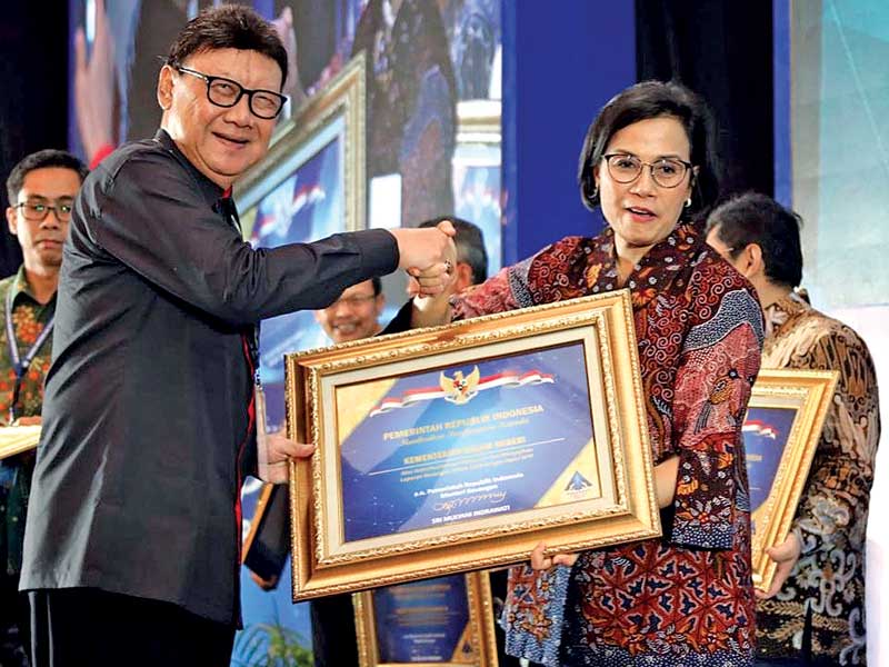 Sri Mulyani Indrawati (kanan) menyerahkan Penghargaan Opini Wajar Tanpa Pengecualian (WTP) kepada Menteri Dalam Negeri Tjahjo Kumolo.