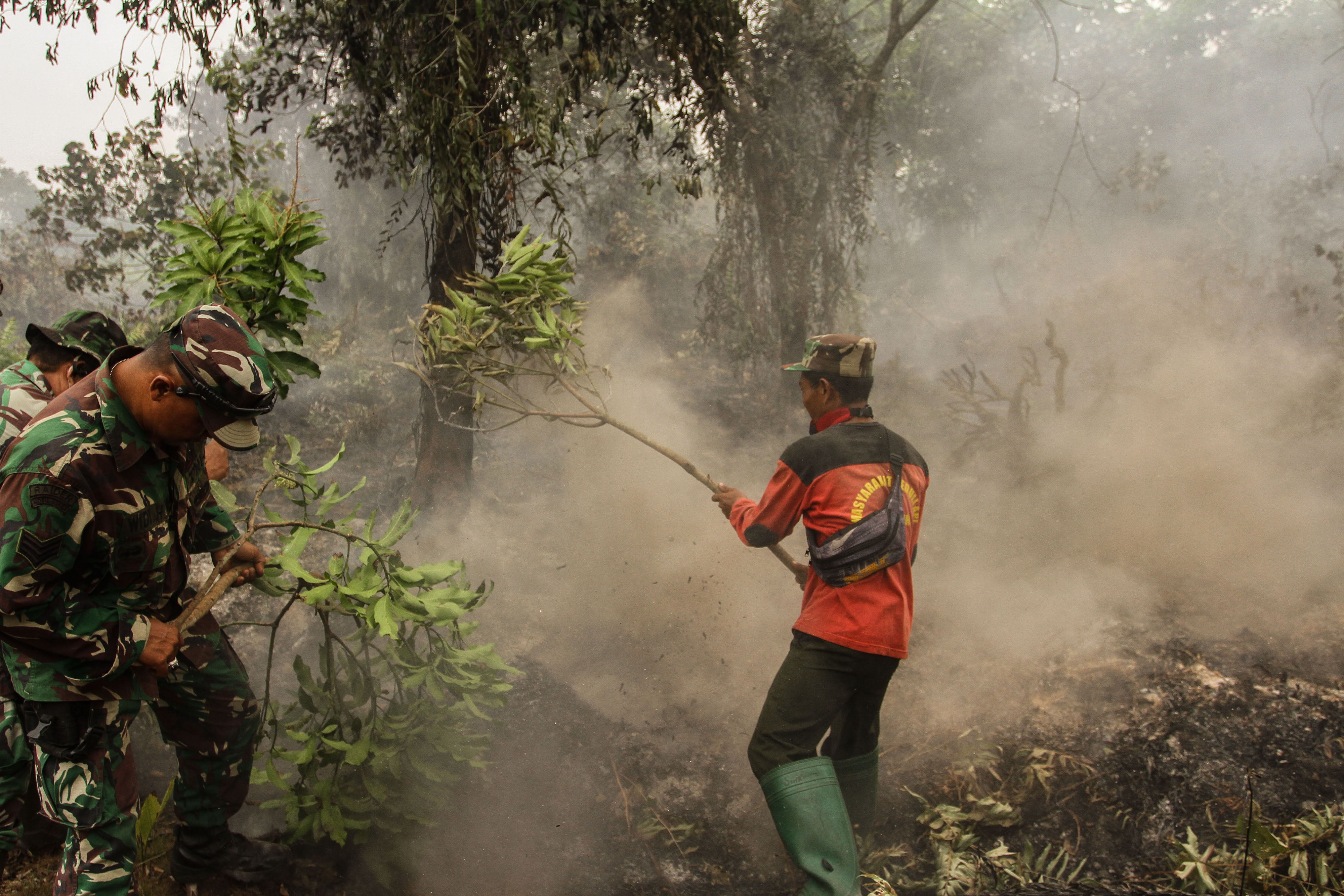Prajurit TNI dari Kodim 0301 Kota Pekanbaru dibantu Masyarakat Peduli Api (MPA) berusaha memadamkan karhutla di lahan gambut di Riau.