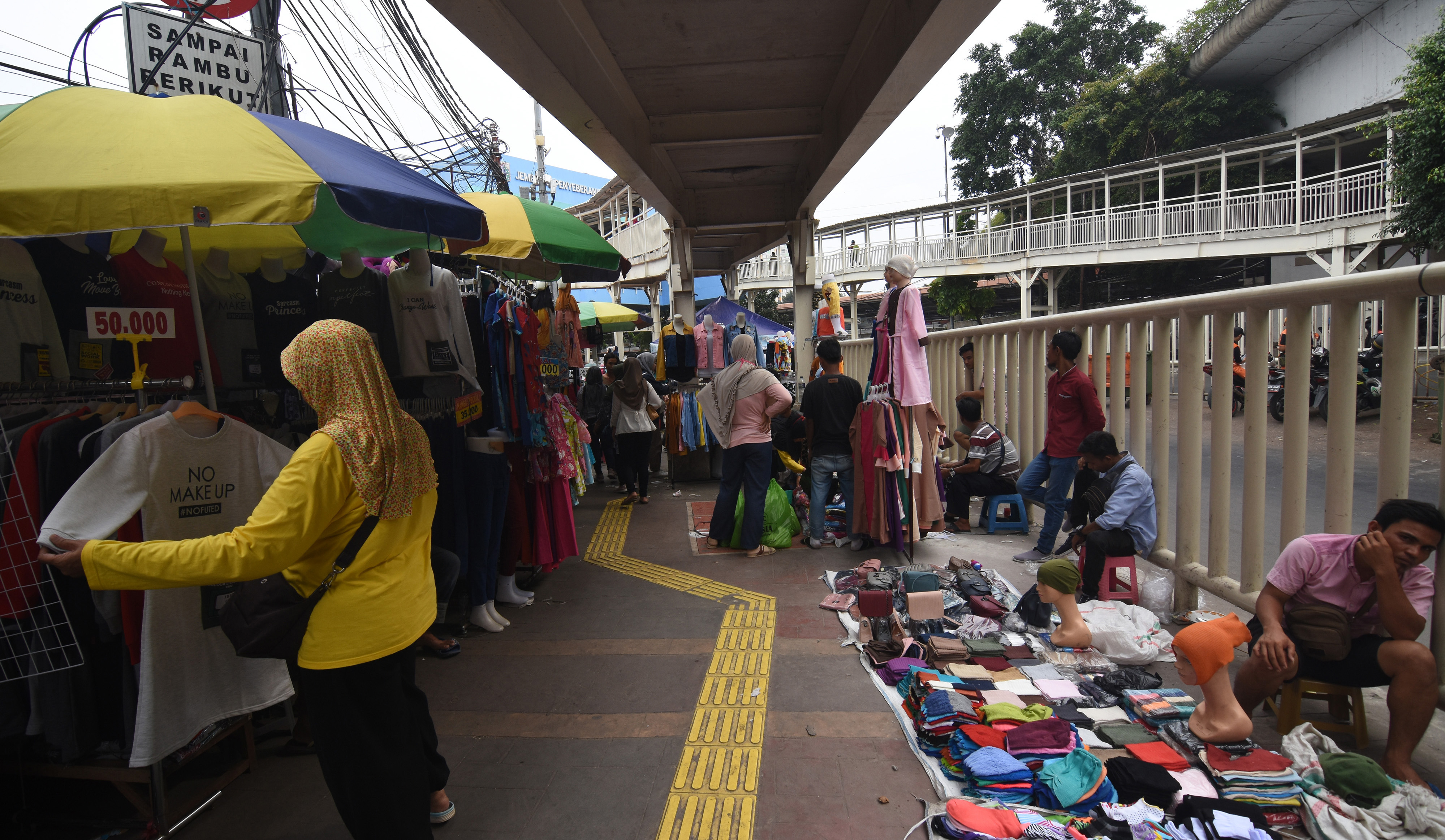 Warga melihat barang dagangan yang dijual pedagang kaki lima (PKL) di trotoar Tanah Abang