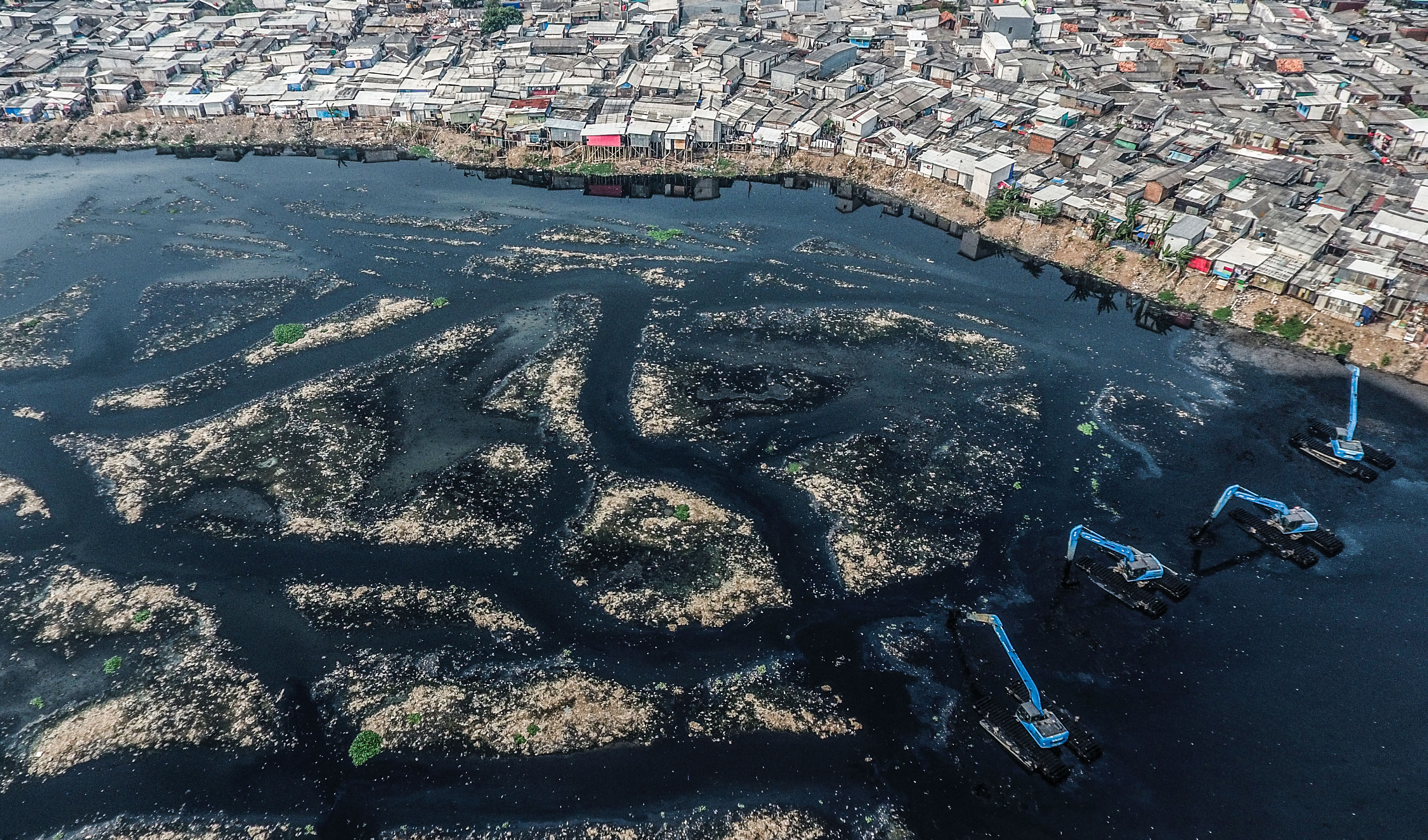 Foto udara pekerja menggunakan eskavator melakukan pengerukan Waduk Pluit, Jakarta Utara, Sabtu (22/6). 