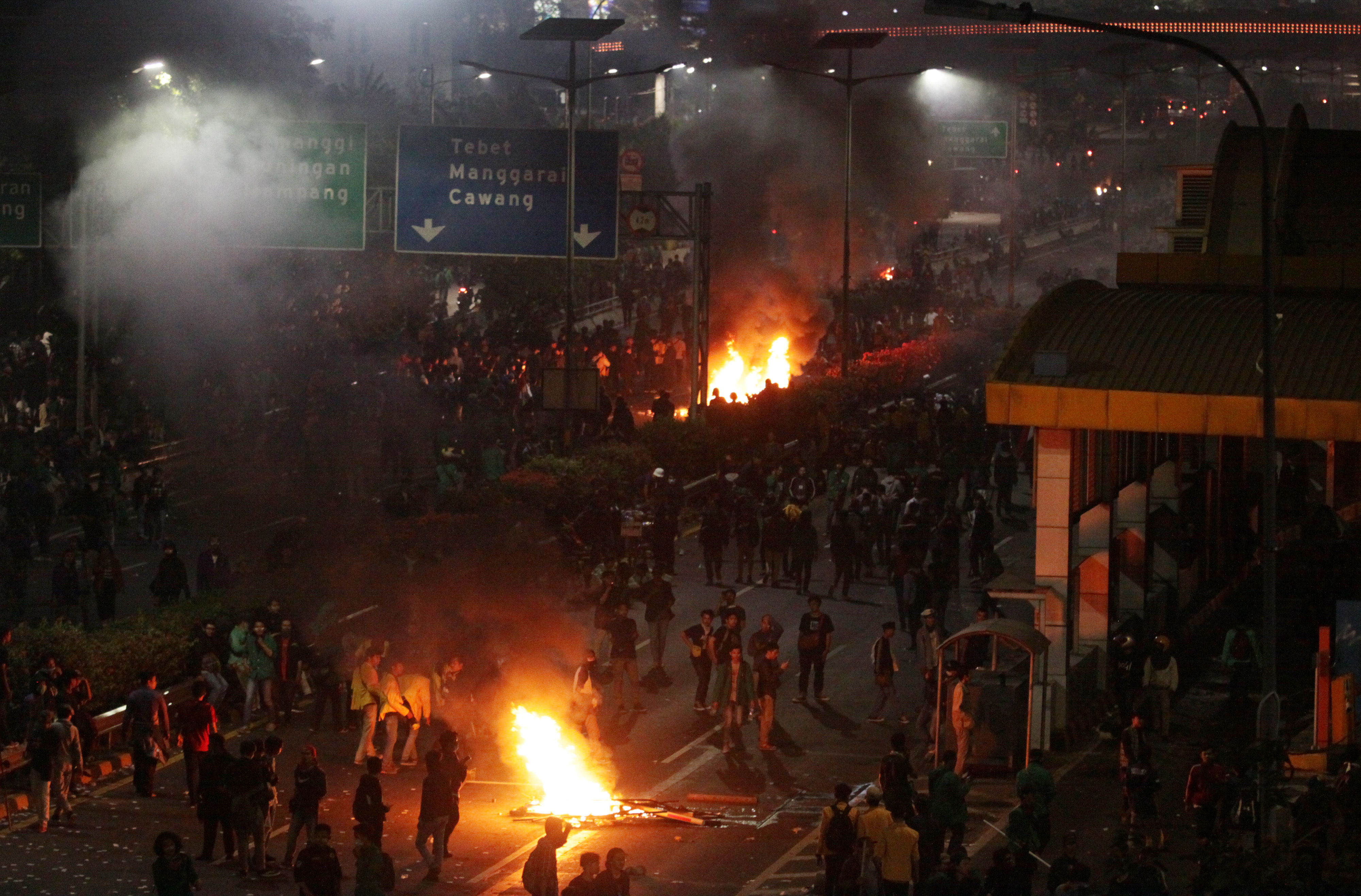 Massa membakar pembatas jalan saat berunjuk rasa di Jalan Gatot Subroto, Jakarta, hari ini.