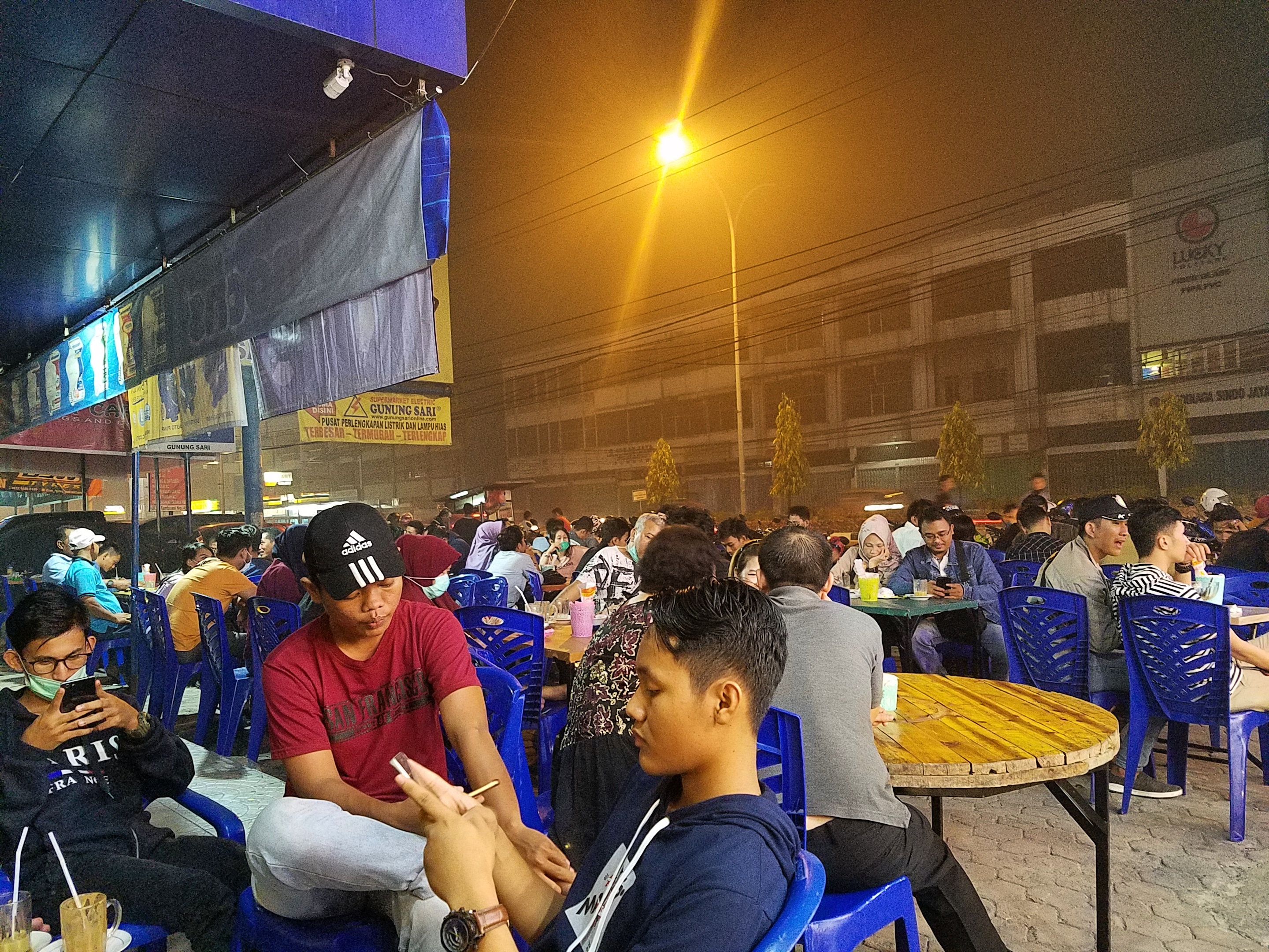 Warga Pekanbaru ramai-ramai nongkrong di kafe tanpa masker di tengah kabut asap pekat, Minggu (22/9). 