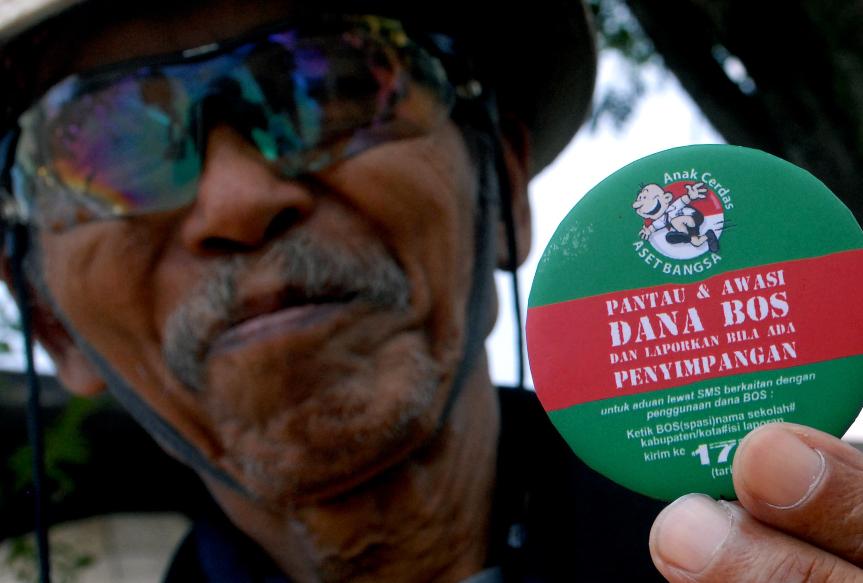  Pegiat anti korupsi Abah Landung (84) memperlihatkan pin pengawasan dana Biaya Operasional Sekolah (BOS) di Bandung,