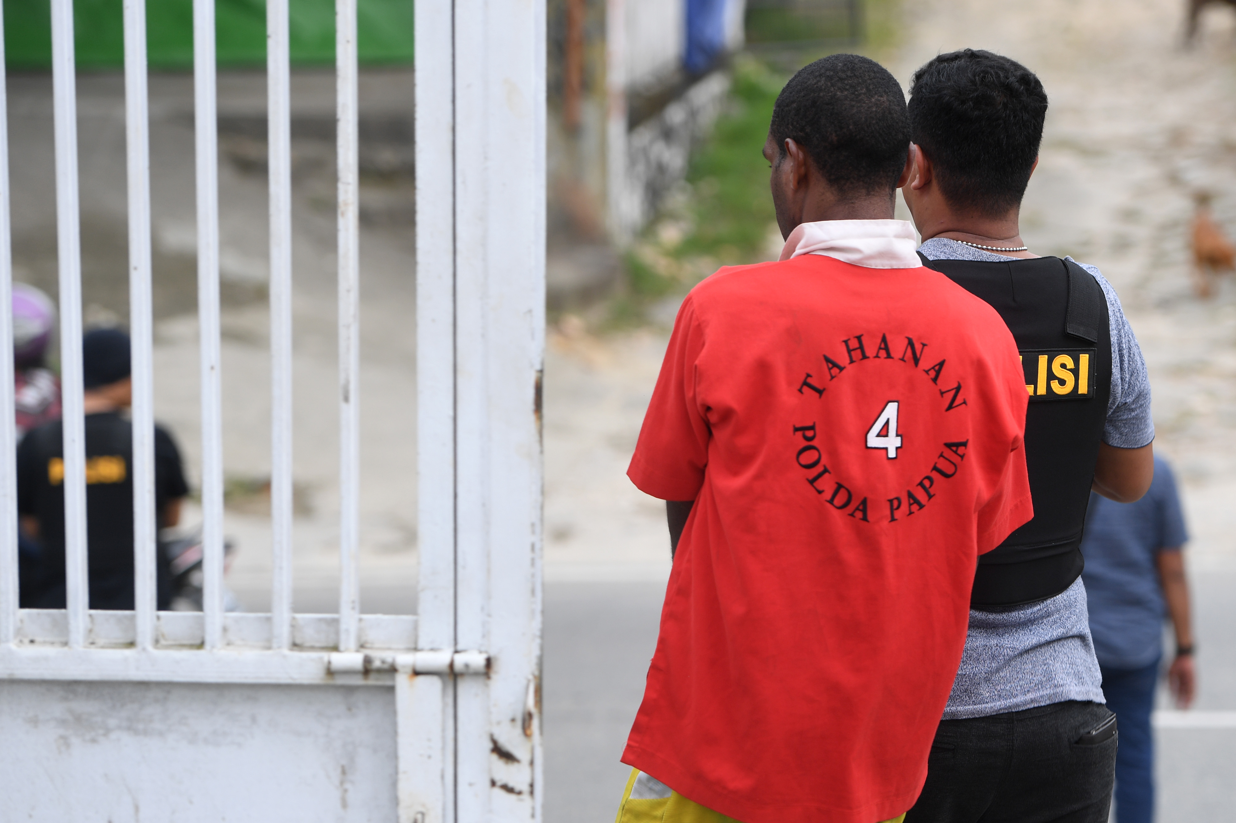 Polisi menggiring salah satu tersangka kasus unjuk rasa Papua.