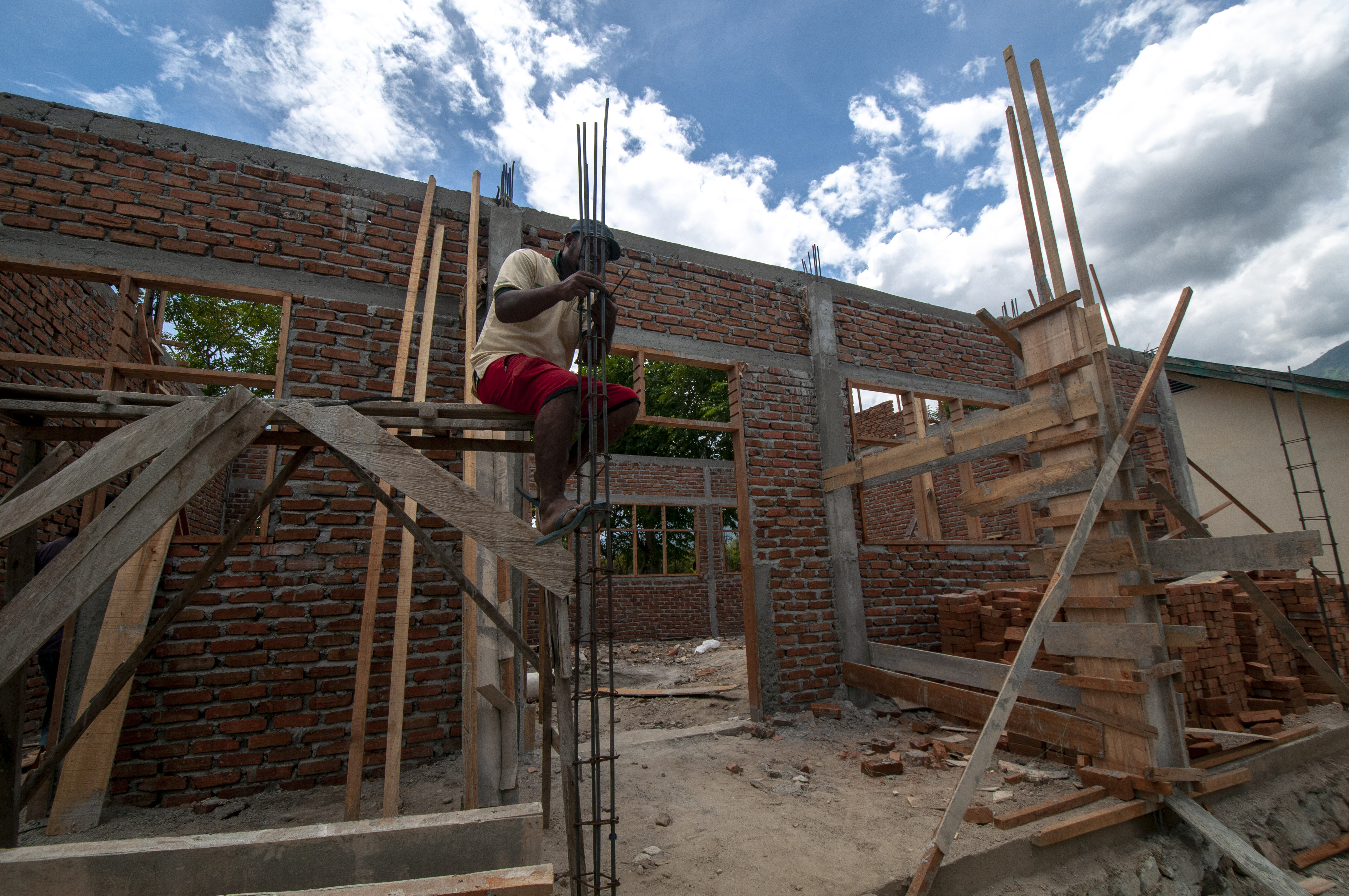 ilustrasi -- seorang pekerja menyiapkan rangka besi beton pada perbaikan gedung sekolah yang rusak.
