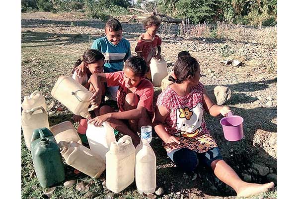 Warga antre untuk mengambil air pada galian mata air di sungai yang mengering di Desa Reroroja, Kecamatan Magepanda, Sikka, NTT, kemarin.