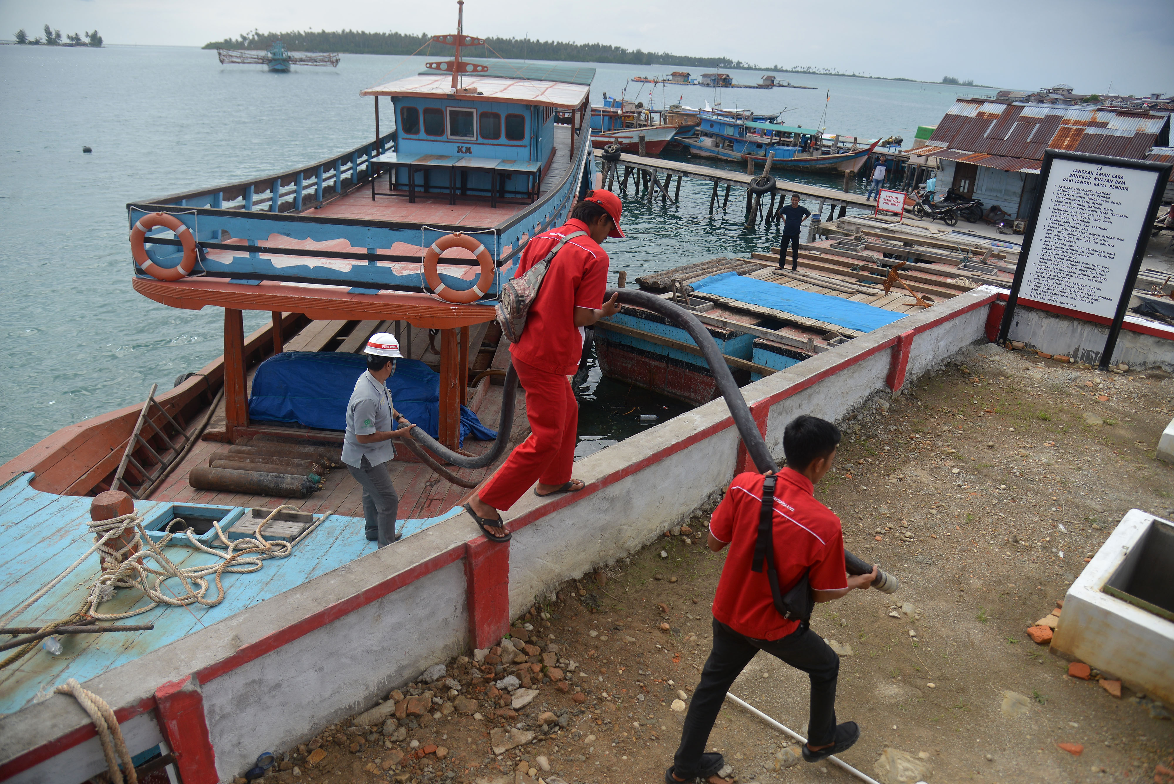 ilustrasi -- karyawan mendistribusikan BBM premium dan solar dari kapal ke tangki penyimpanan di SPBU di kawasan 3T