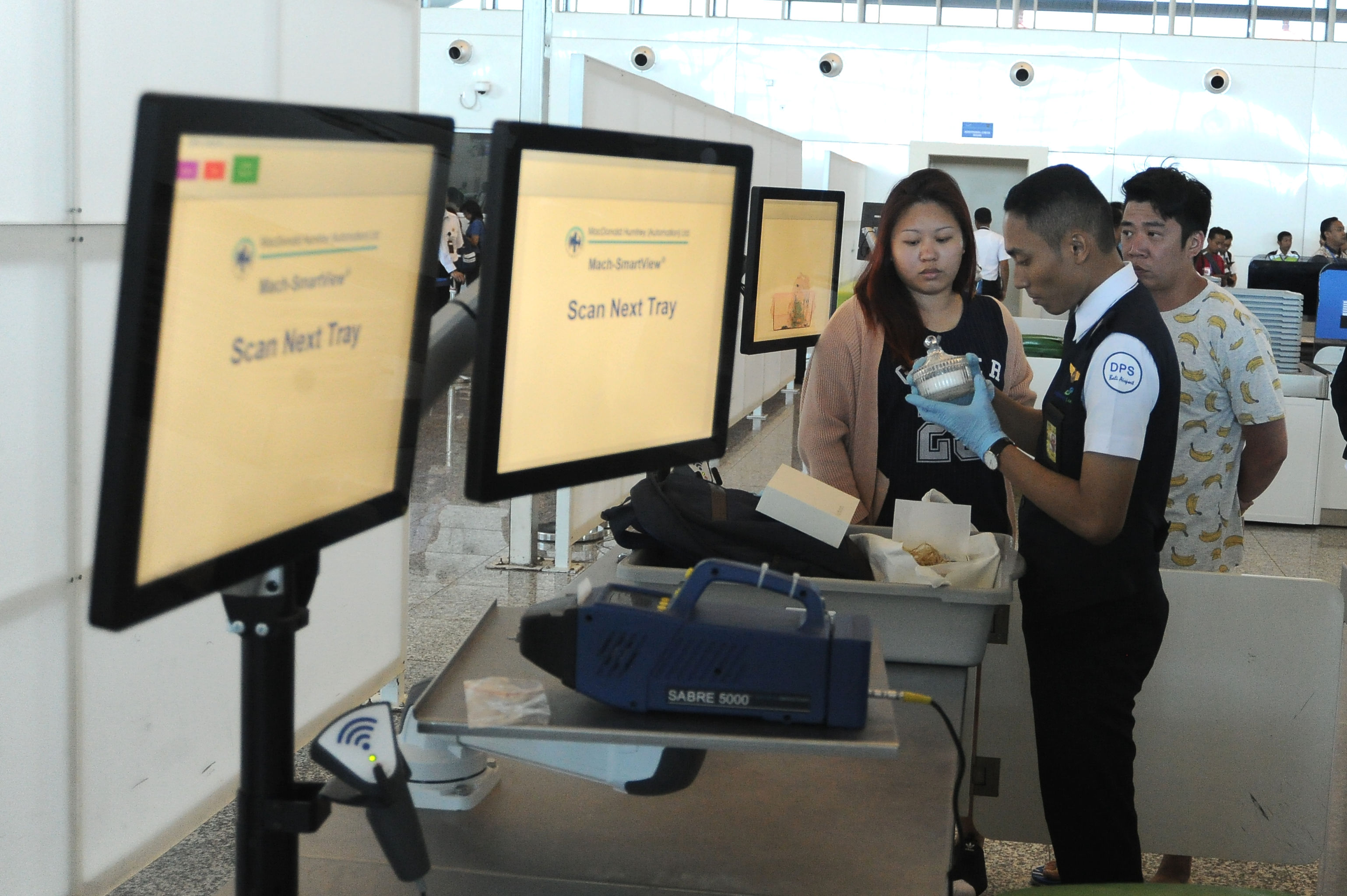 Petugas memeriksa barang bawaan calon penumpang yang telah dipindai X-ray ATRS di Terminal Internasional Bandara I Gusti Ngurah Rai