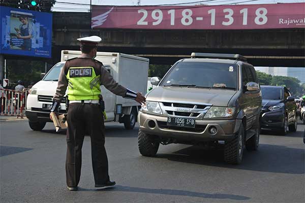 Polisi menghentikan kendaraan roda empat berplat genap di Jalan RS. Fatmawati Raya, Jakarta Selatan, Senin (9/9/2019).