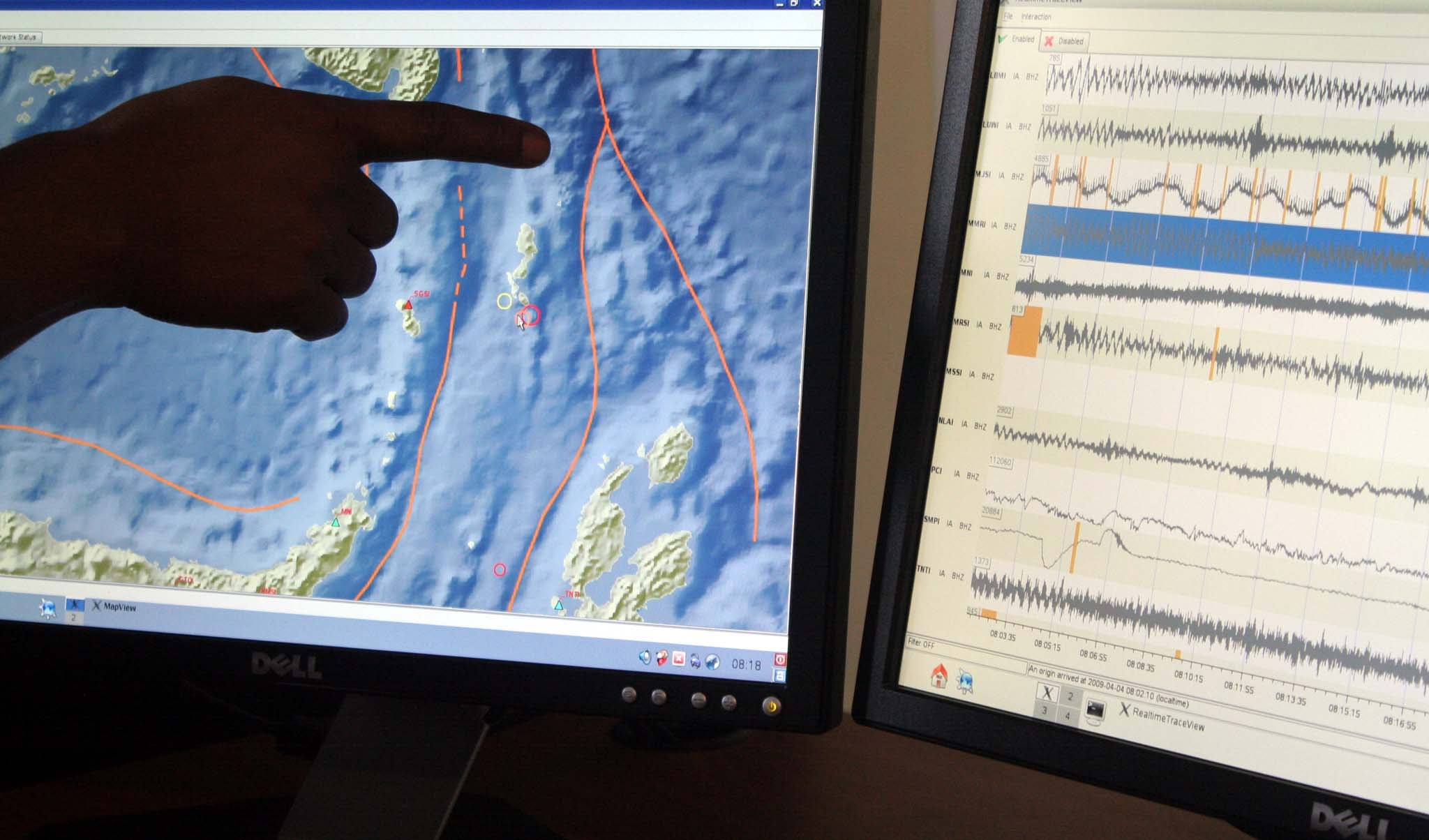 Seorang petugas Badan Meteorologi dan Geofisika menunjuk lokasi gempa.