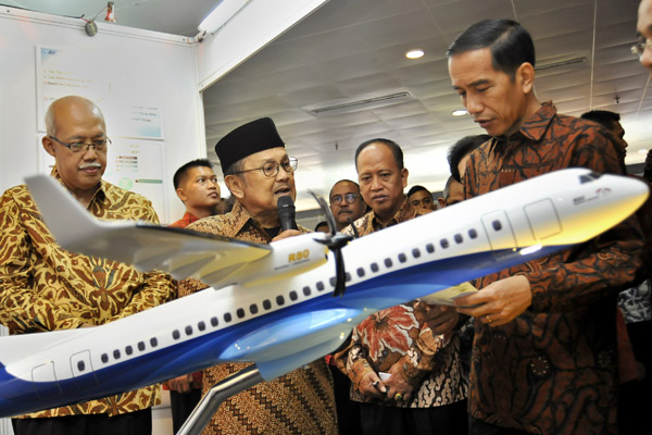 Presiden Joko Widodo (kanan) mendengarkan penjelasan dari Presiden ke-3 RI BJ Habibie (kedua kiri) mengenai industri penerbangan.
