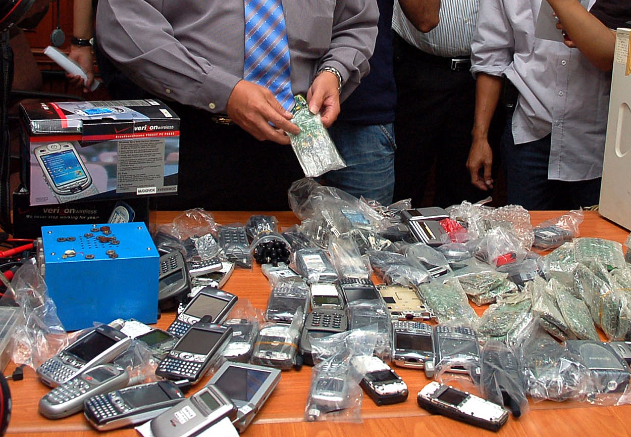  Petugas menunjukkan bukti telepon genggam rakitan dan rekondisi dengan tersangka Muhammad Ali (39) di Polda Metro Jaya, Senin (11/8)