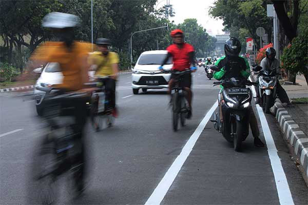 Pengendara sepeda di luar jalur sepeda karena terhalang pengendara motor di Jalan Medan Merdeka Selatan, Jakarta Pusat, Jumat (20/9)