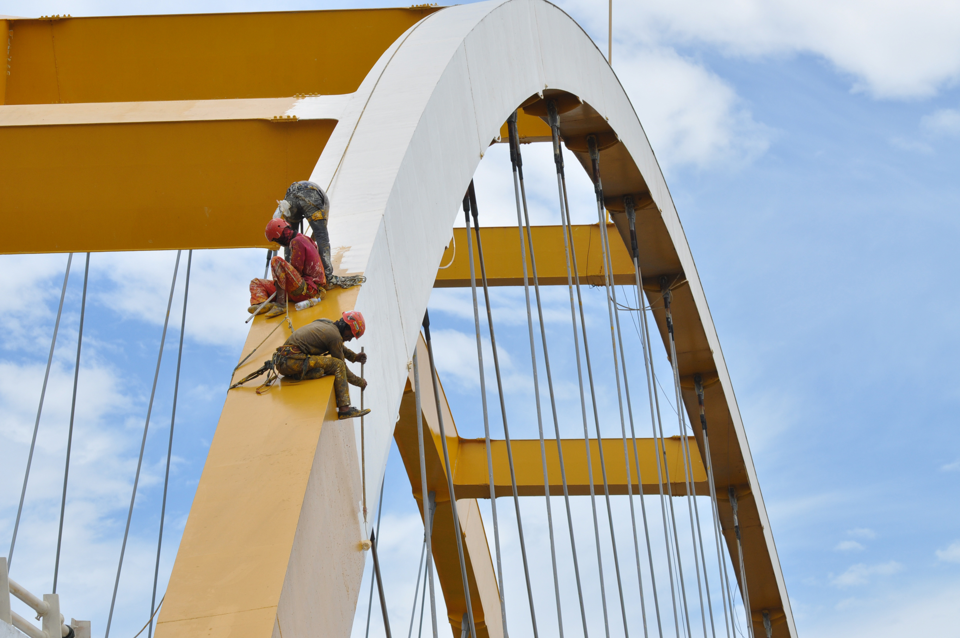 Sejumlah pekerja mengenakan alat pengaman dan pelindung diri saat mengecat jembatan kuning di Kawasan Pantai Teluk Palu