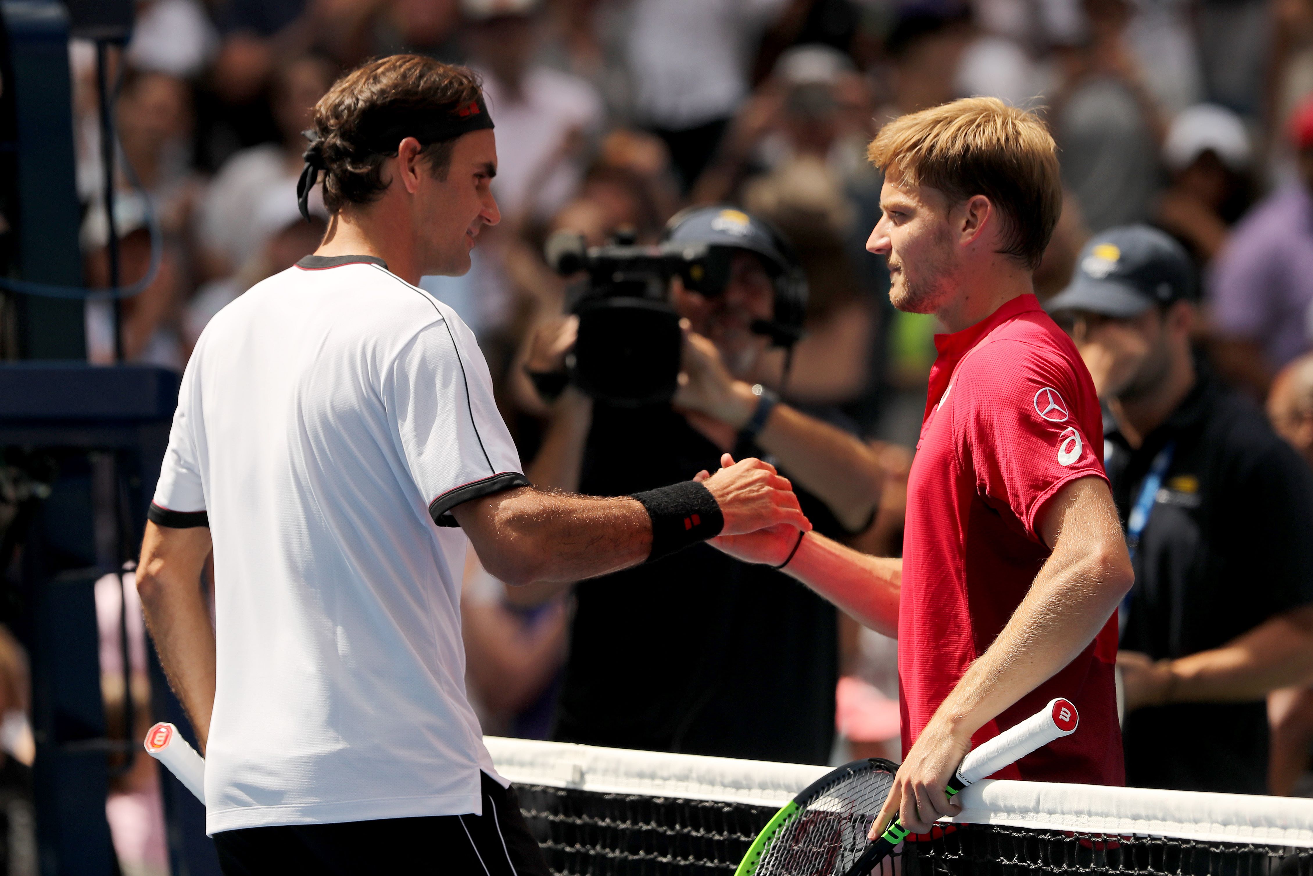 Setelah memenangi laga babak 16 besar, Roger Federer (kiri) bersalaman dengan lawannya David Goffin. 
