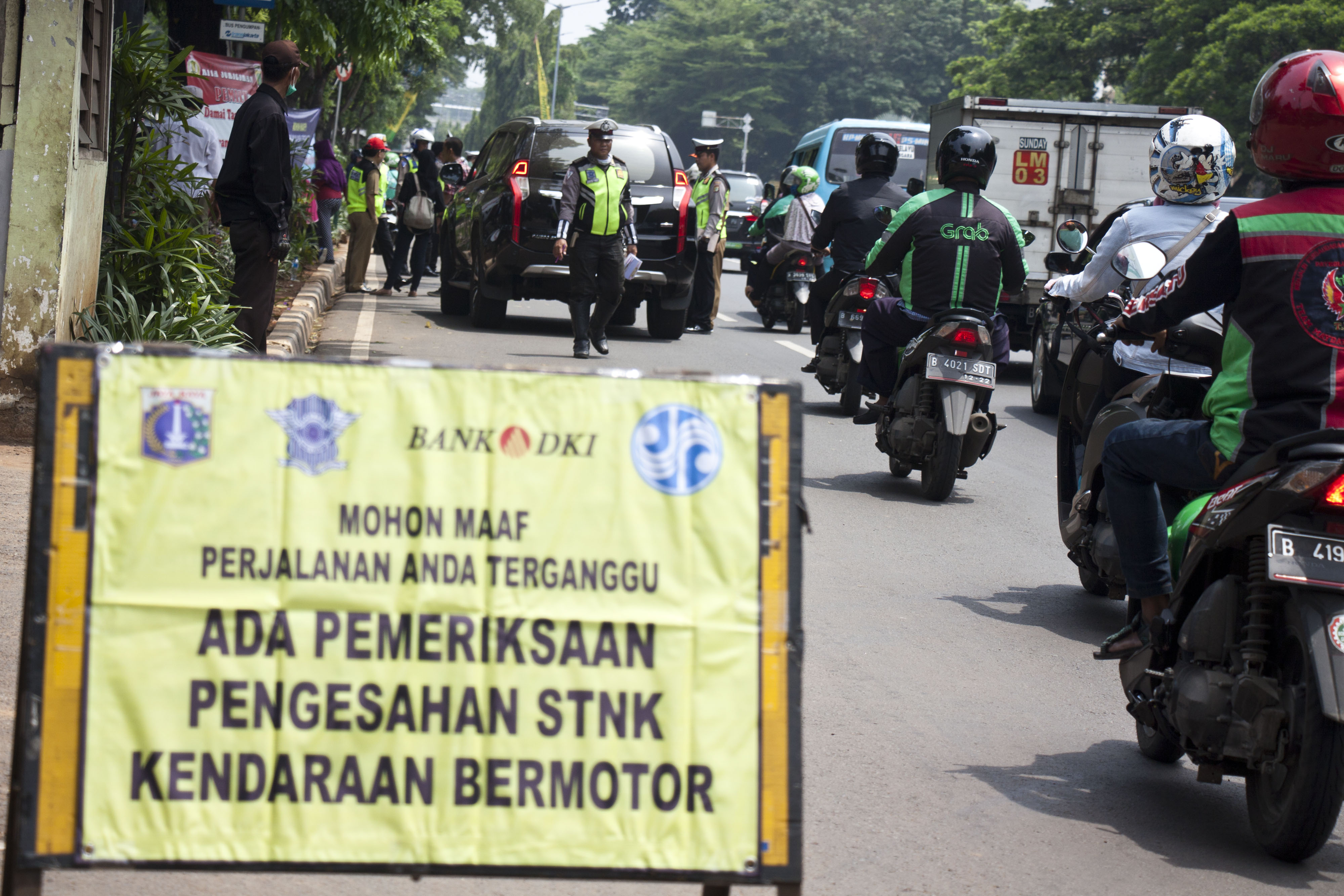 Petugas gabungan memeriksa pajak kendaraan bermotor saat razia pengesahan STNK di kawasan Taman Makam Pahlawan Kalibata
