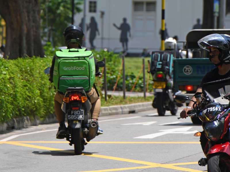 Seorang pengemudi Grabfood mengantarkan makanan ke pelanggan di Singapura