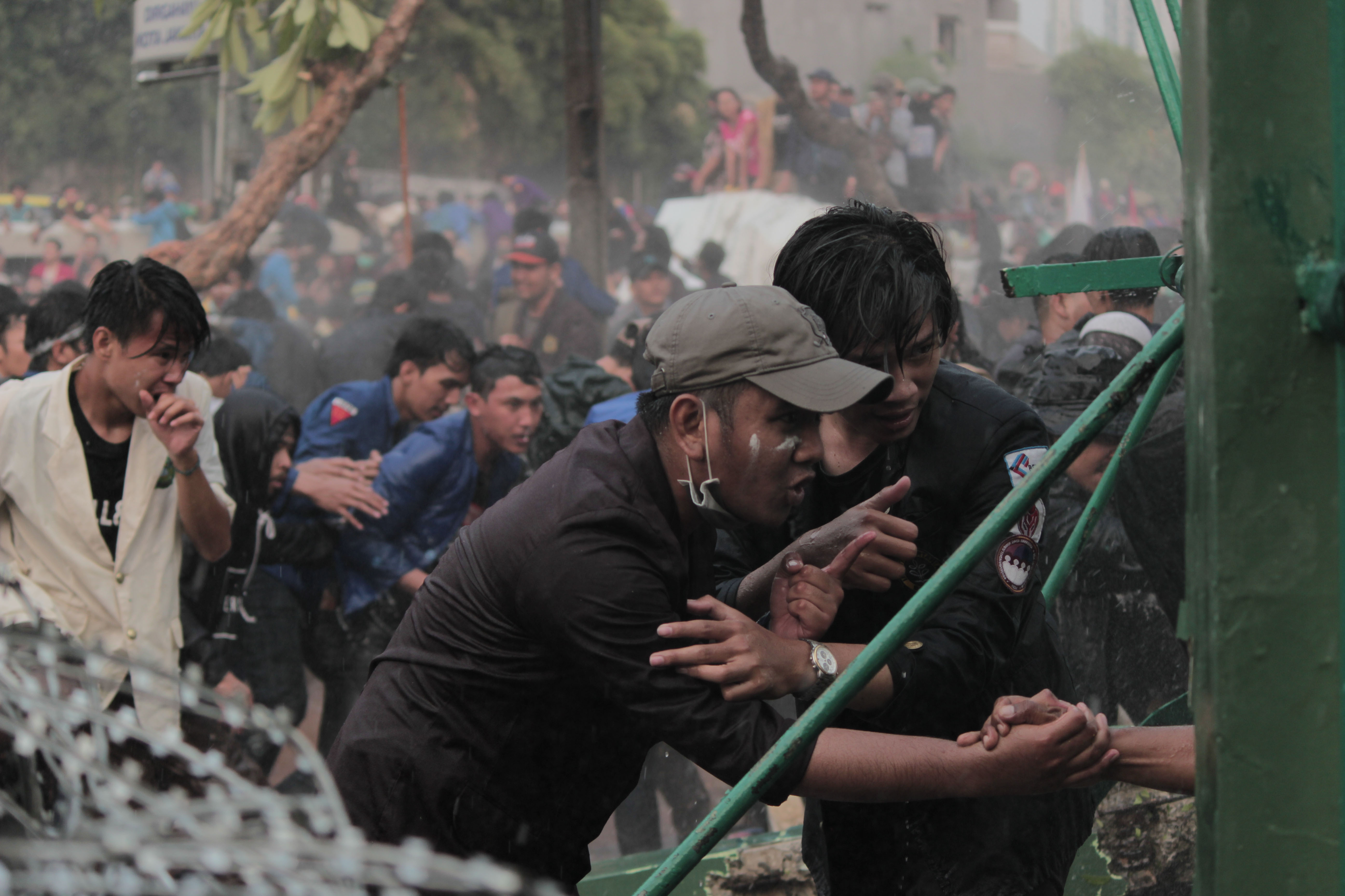 Mahasiswa meminta aparat kepolisian untuk menghentikan penyemprotan air ke arah mahasiswa di Gedung DPR/MPR RI, Jakarta Pusat, Selasa (24/9.