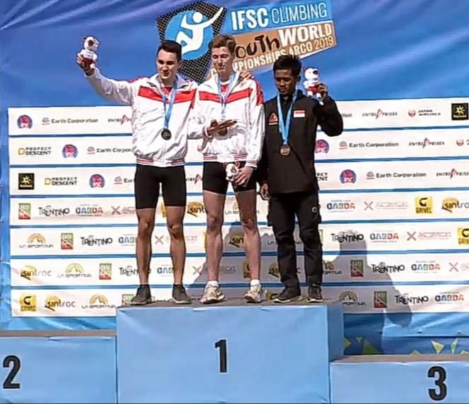 Atlet panjat tebing Indonesia Adi Mulyono (kanan) di atas podium seusai mendapat medali.