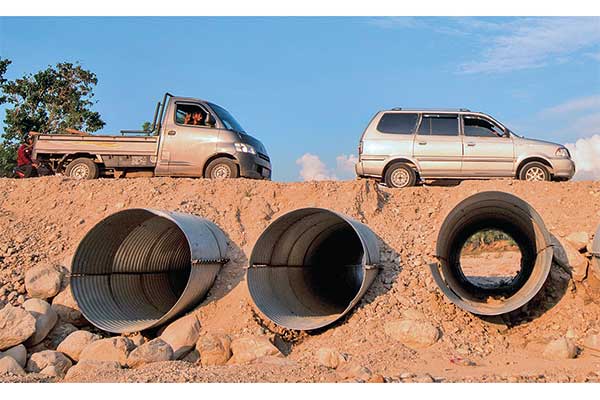Pengendara melintas di jalan hasil penimbunan di atas sungai di Desa Pombewe, salah satu desa tertinggal di Kabupaten Sigi, Sulawesi Tengah,
