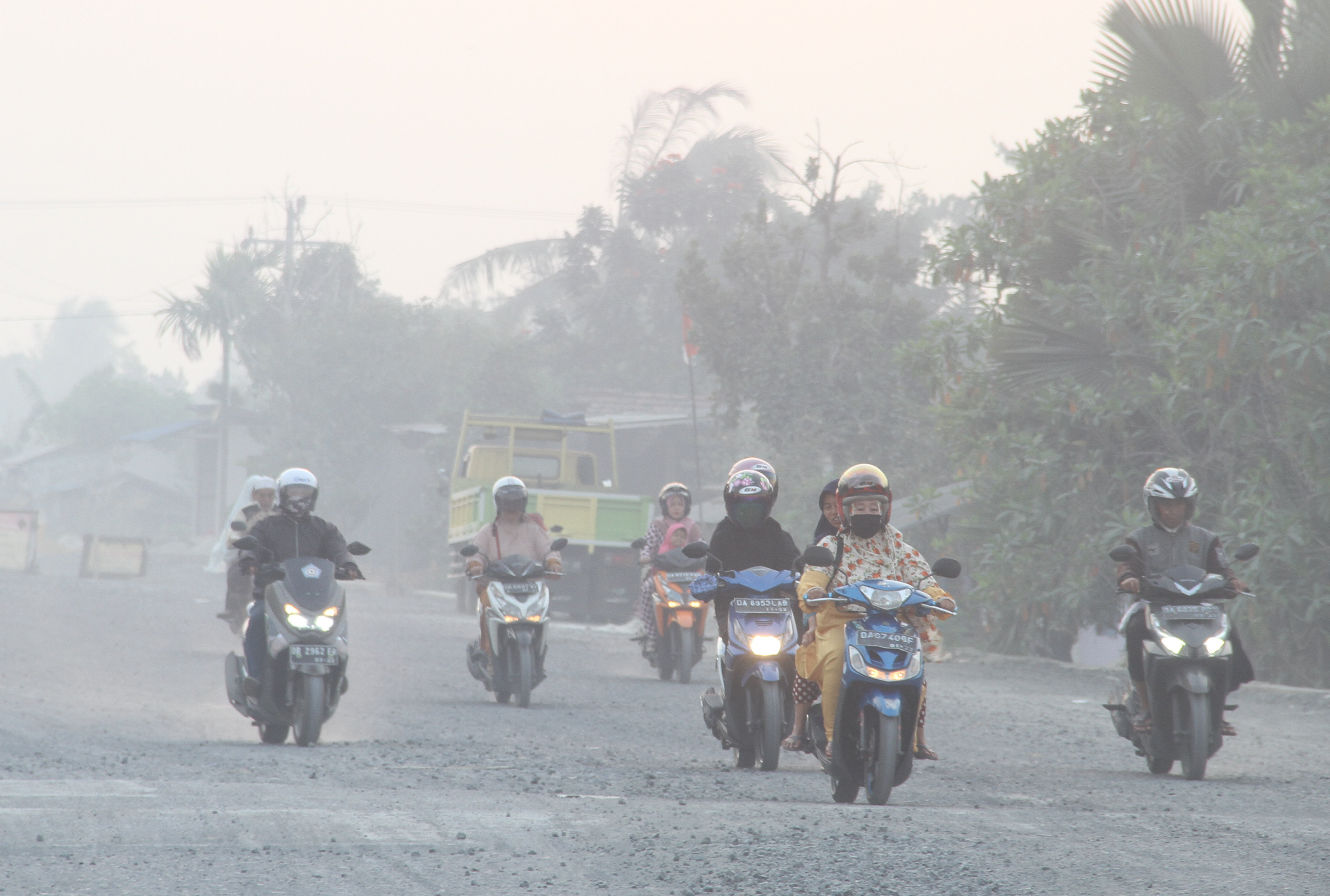 Sejumlah kendaraan bermotor melintas di jalan yang diselimuti kabut asap dari kebakaran hutan dan lahan di Banjar Baru, Kalimantan Selatan.