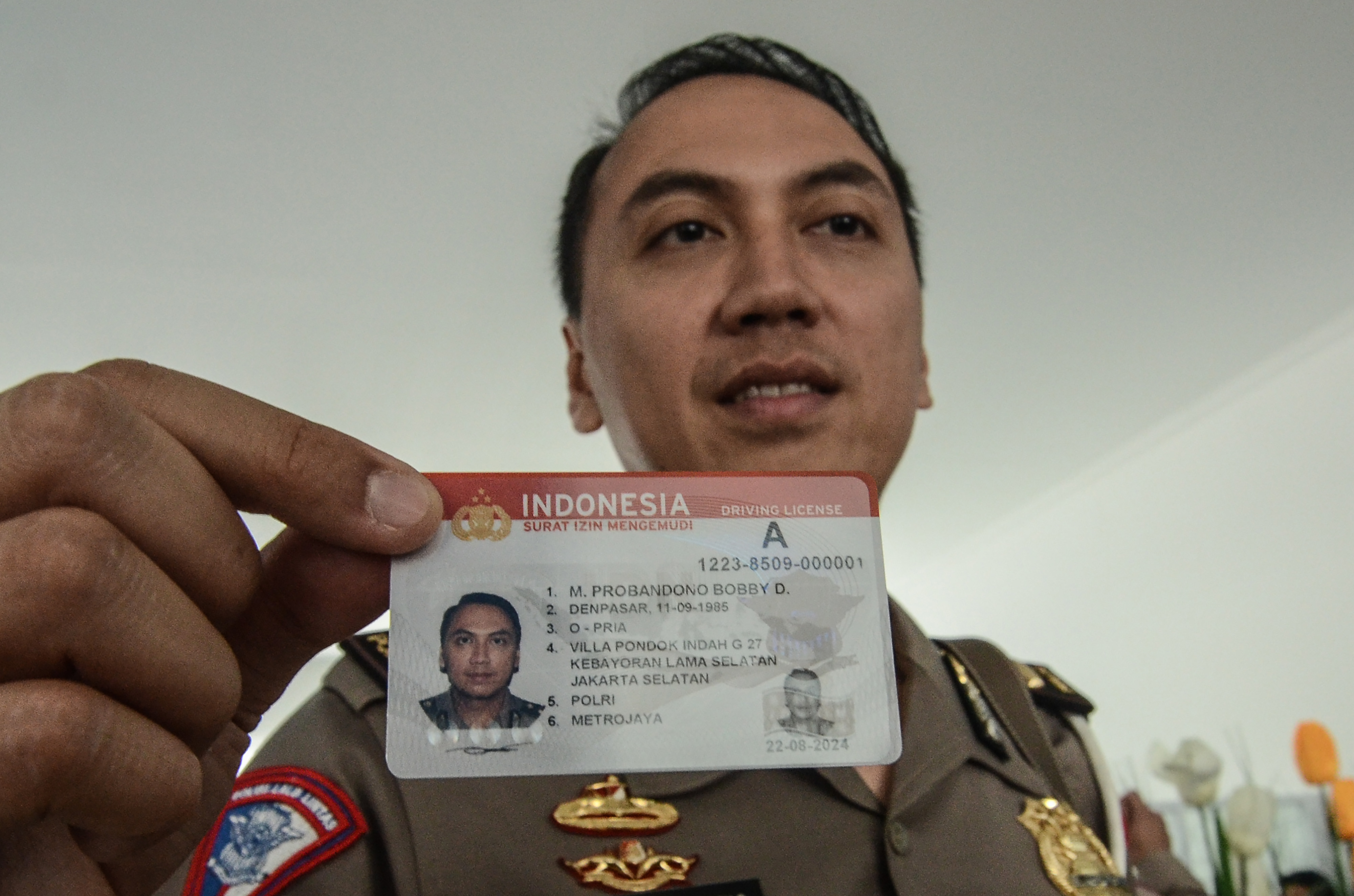 Polisi menunjukkan kartu Smart SIM (Surat Izin Mengemudi) di Gedung Satuan Penyelenggara Administrasi (Satpas), Kabupaten Bekasi, Jawa Barat