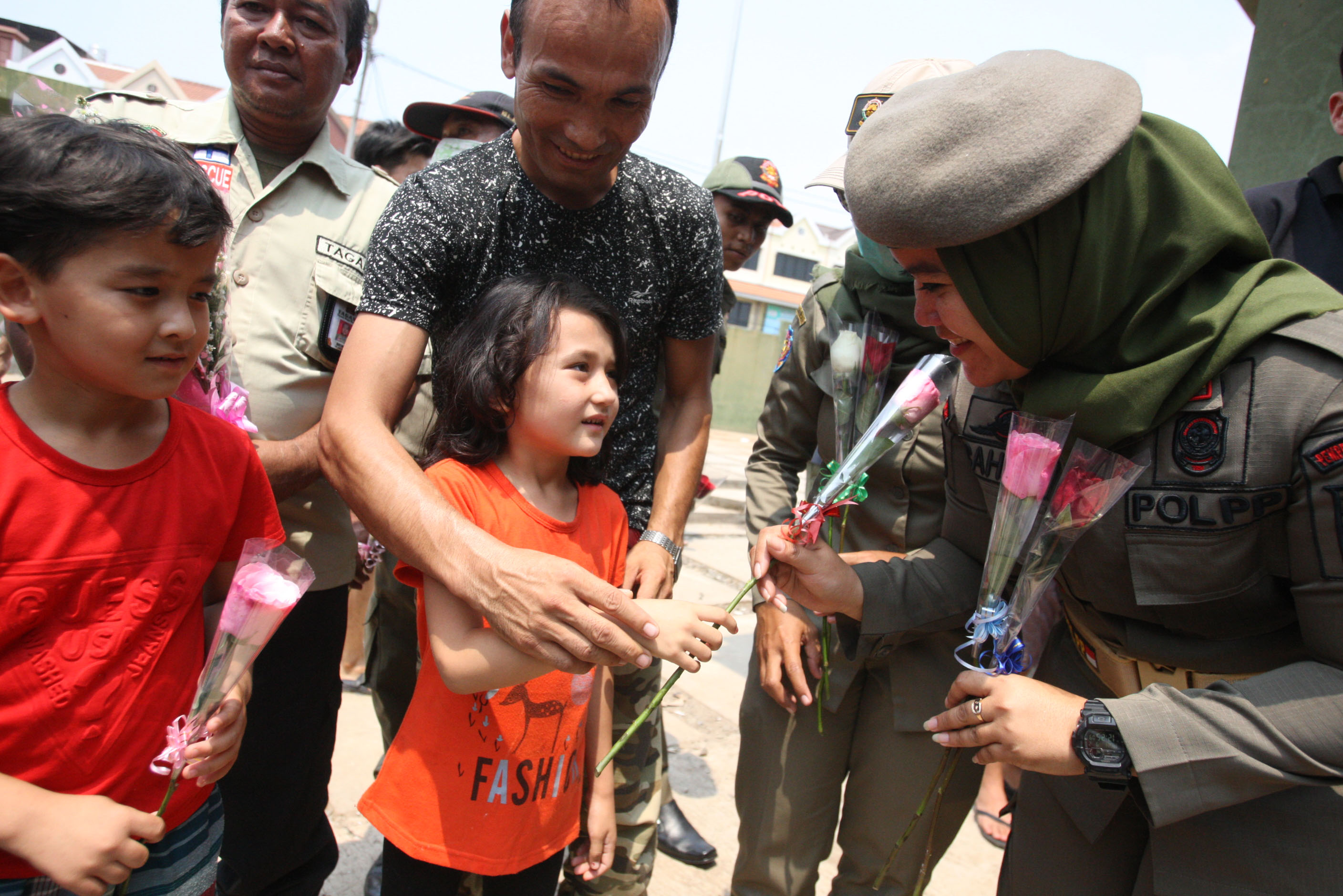Anak-anak pencari suaka memberikan bunga kepada petugas dan warga Indonesia sebagai ucapan terima kasih.