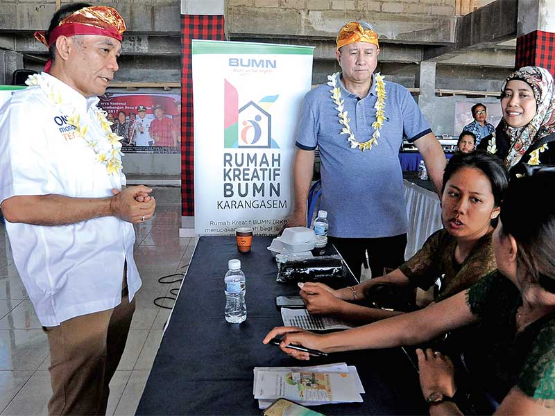 Direktur Bank Mandiri Donsuwan Simatupang (kiri) berbincang dengan pelaku UMKM binaan Bank Mandiri 