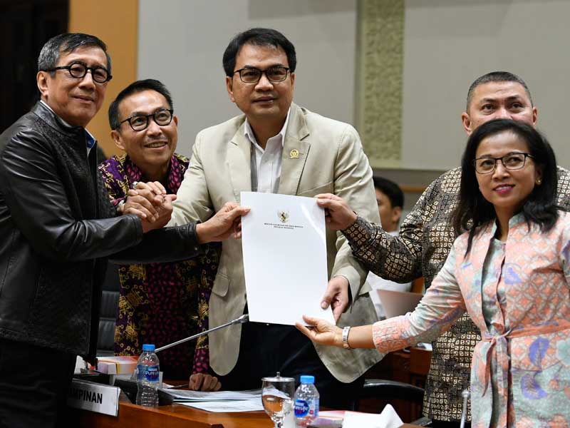 Menteri Hukum dan HAM Yasonna Laoly (kiri) menyerahkan tanggapan pemerintah kepada Ketua Komisi III DPR Aziz Syamsuddin.