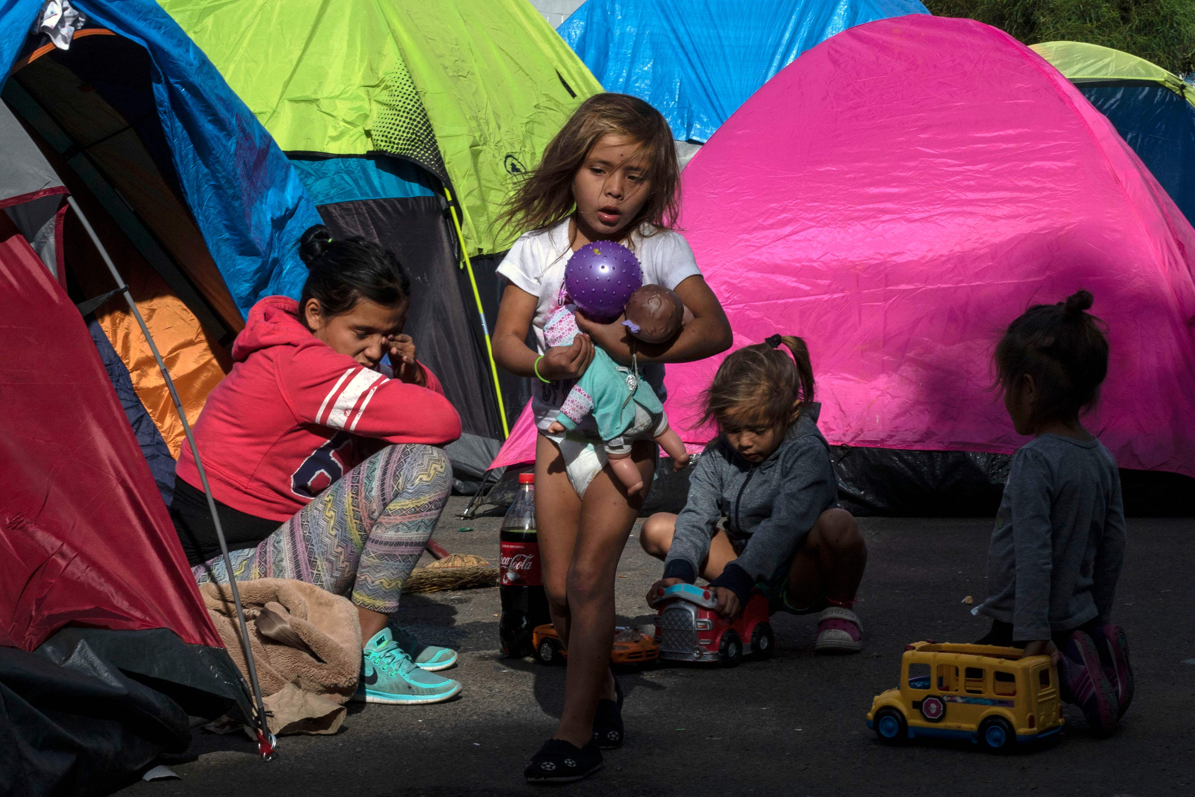 Anak-anak bagian dari karavan migran Amerika Tengah berkemah di dekat tempat penampungan sementara beberapa meter dari perbatasan AS-Meksiko