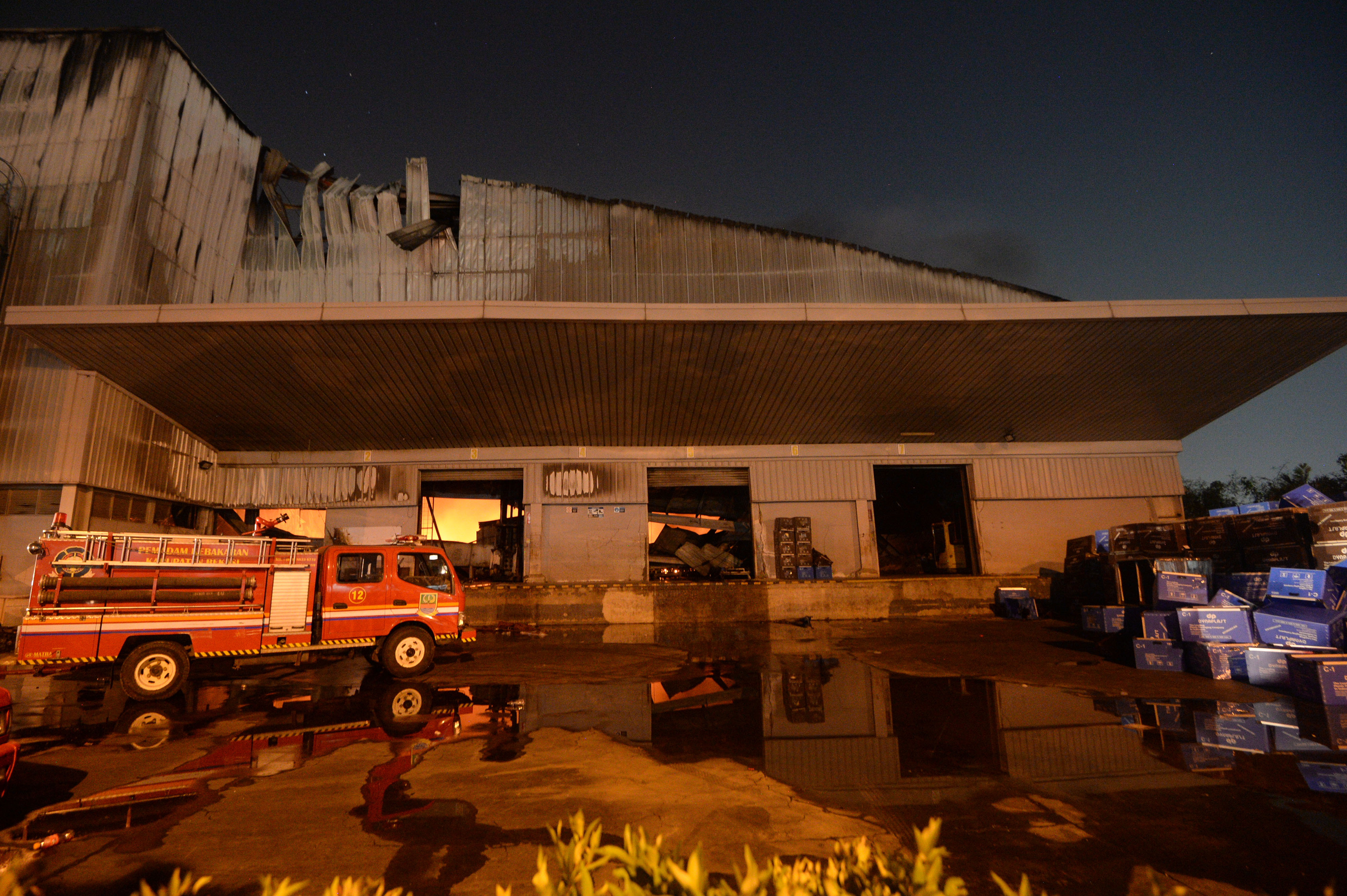 Petugas memadamkan kebakaran gudang barang bekas di kawasan Bulak Banteng, Surabaya, Jawa Timur, Senin (27/5/2019)