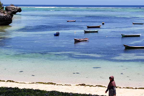 Ilustrasi -- Seorang warga melintas di pesisir Pantai Desa Bo'a, Kecamatan Rote Barat, Kabupaten Rote Ndao, Nusa Tenggara Timur (NTT) 