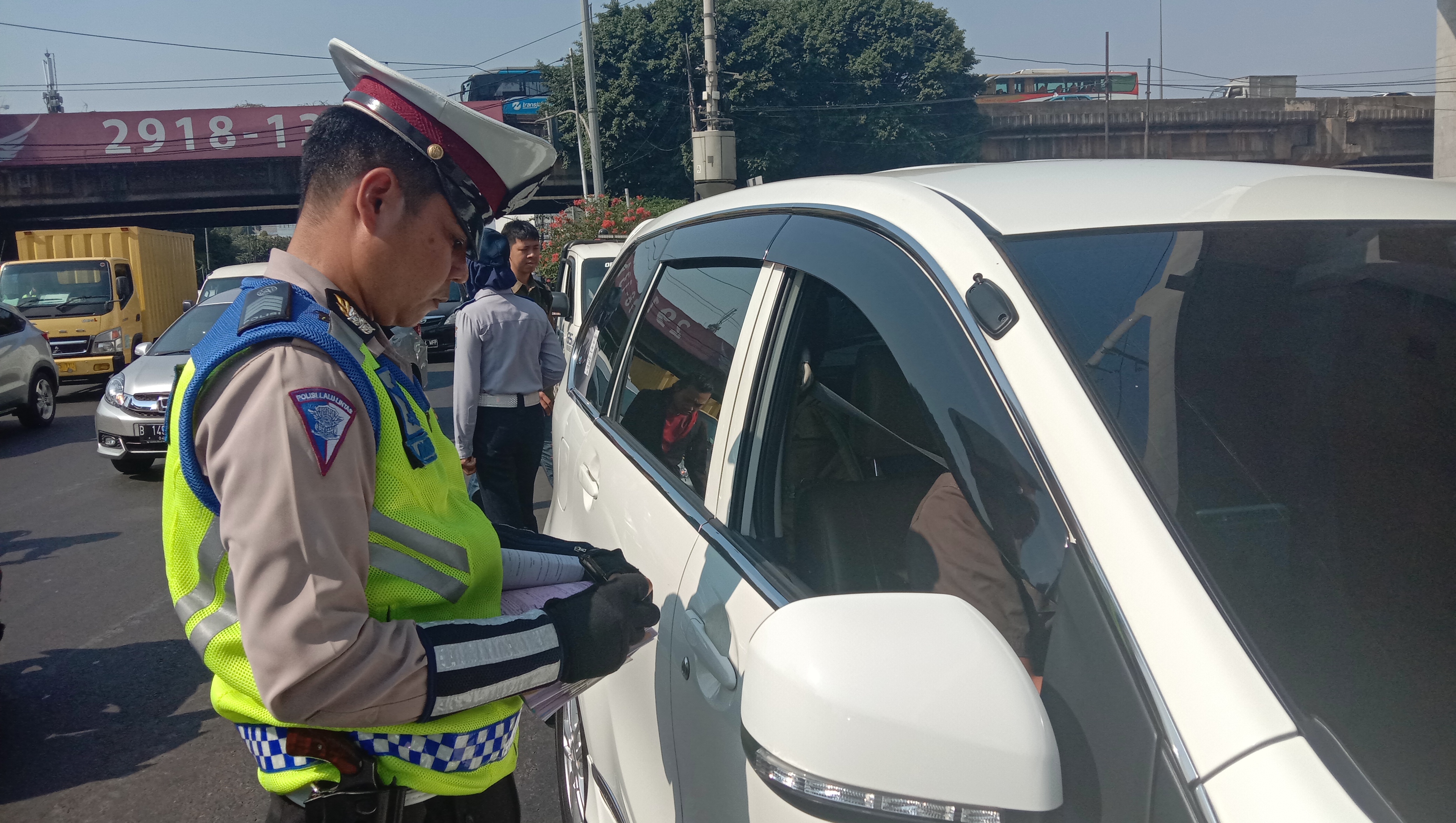 Polisi menilang pengendara yang melanggar ganjil genap di simpang Jalan Panglima Polim Raya, Jakarta Selatan, Selasa (10/9).