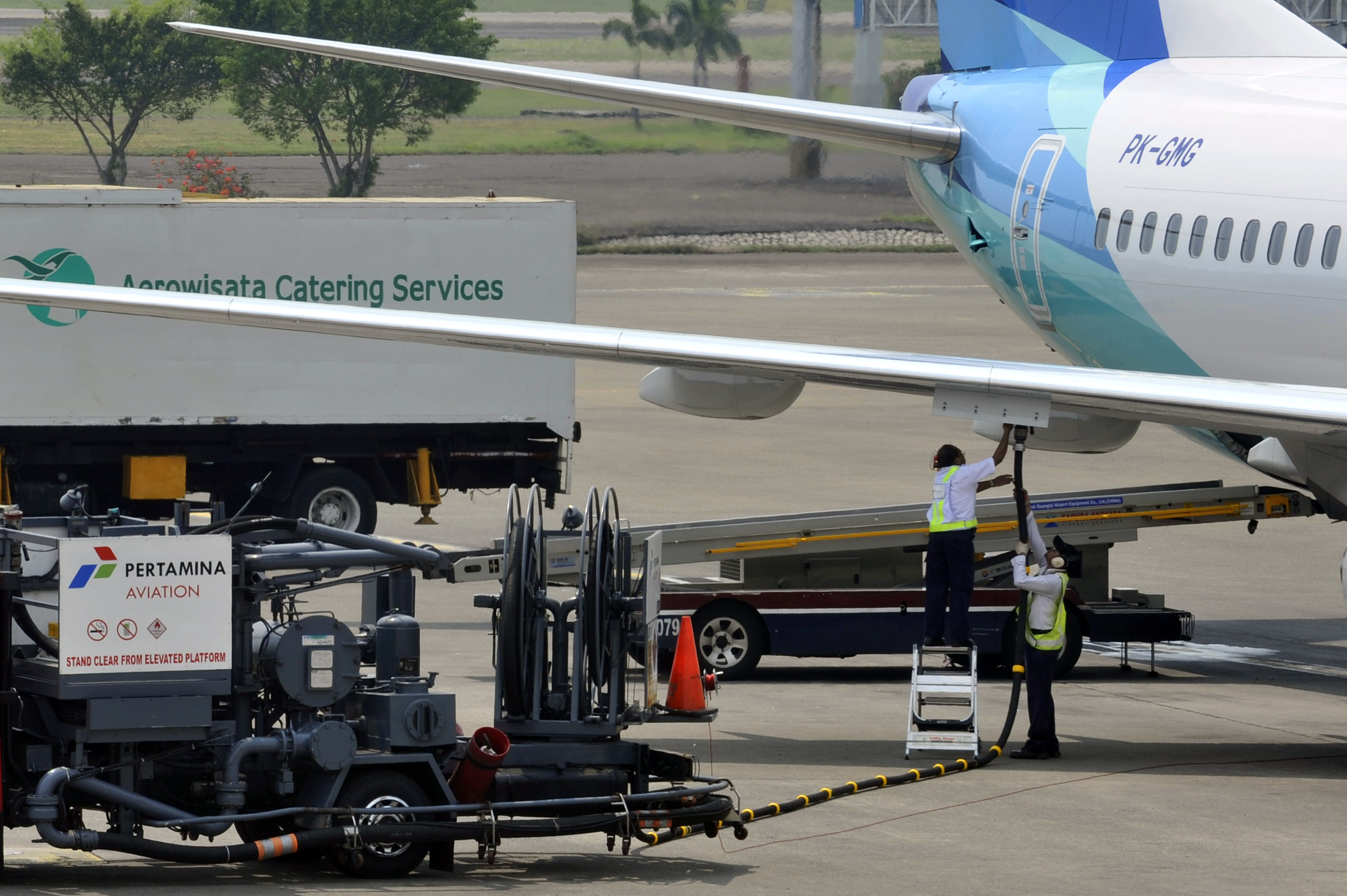 Dua petugas mengisi bahan bakar ke pesawat milik salah satu maskapai penerbangan, di Bandara Soekarno-Hatta