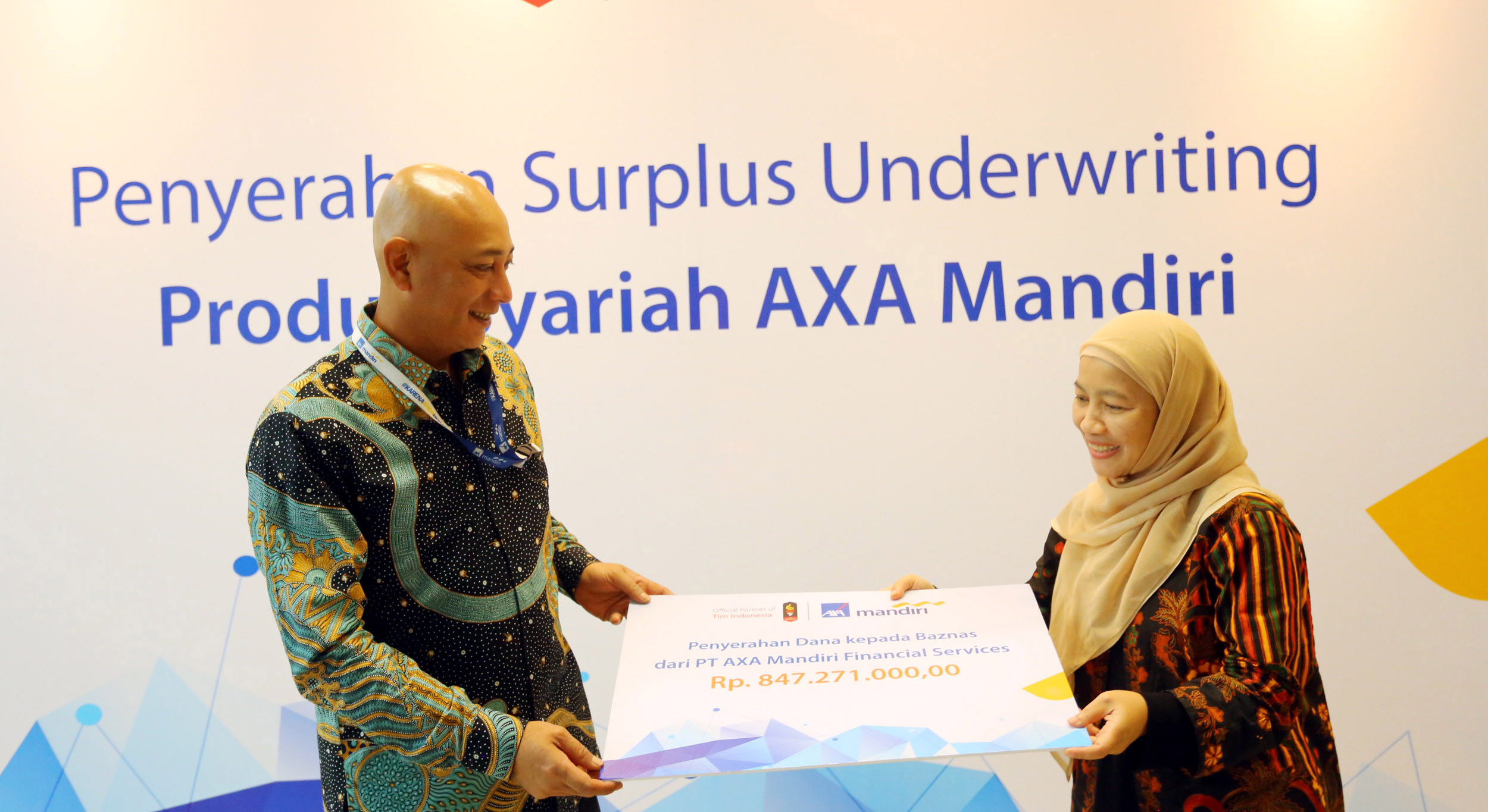  Director of In-Branch Channel AXA Mandiri Henky Oktavianus (kiri) menyerahkan simbolis bantuan dana surplus underwriteng  