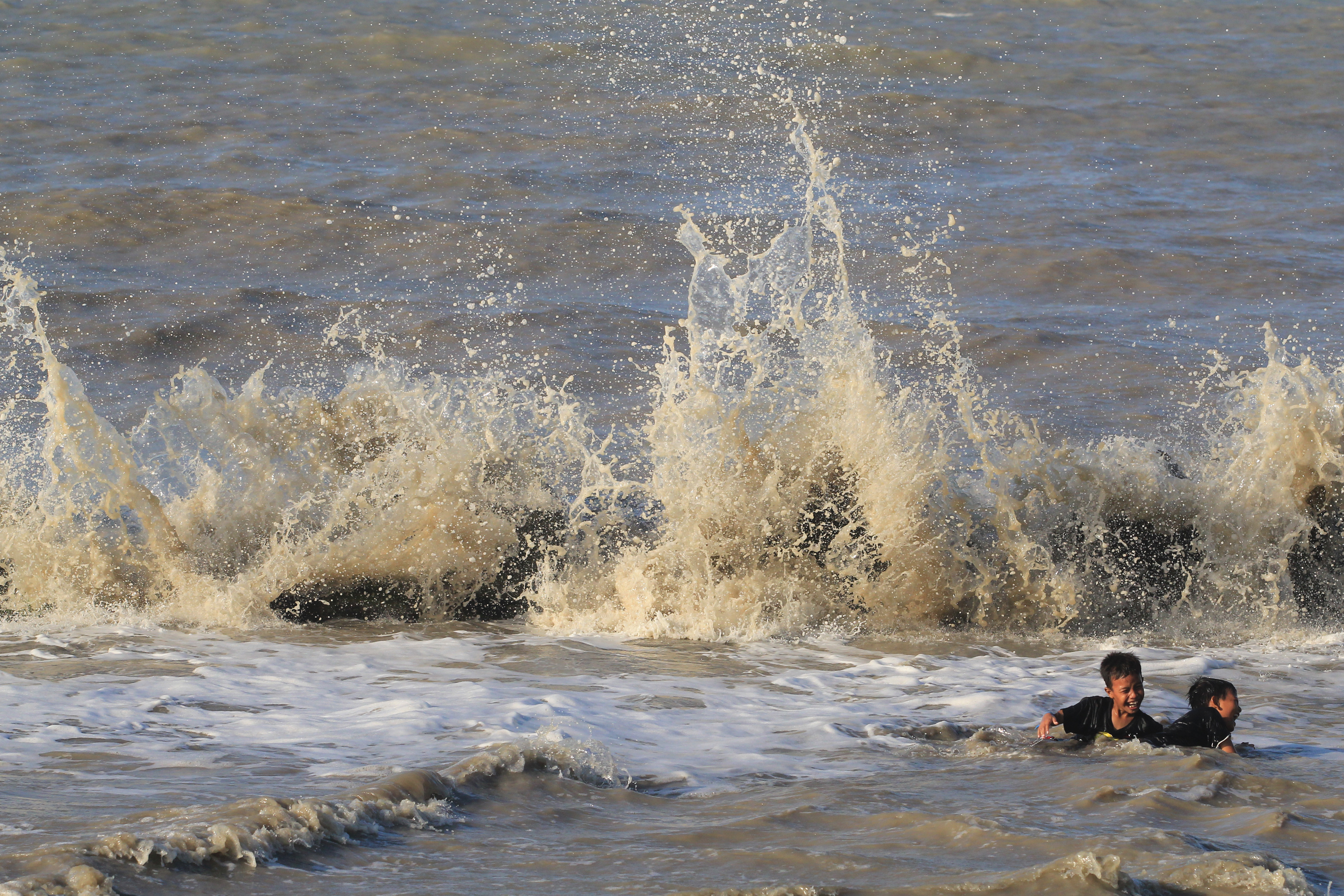 Ilustrasi--Sejumlah anak bermain di antara ombak di pantai Juntinyuat, Indramayu, Jawa Barat.