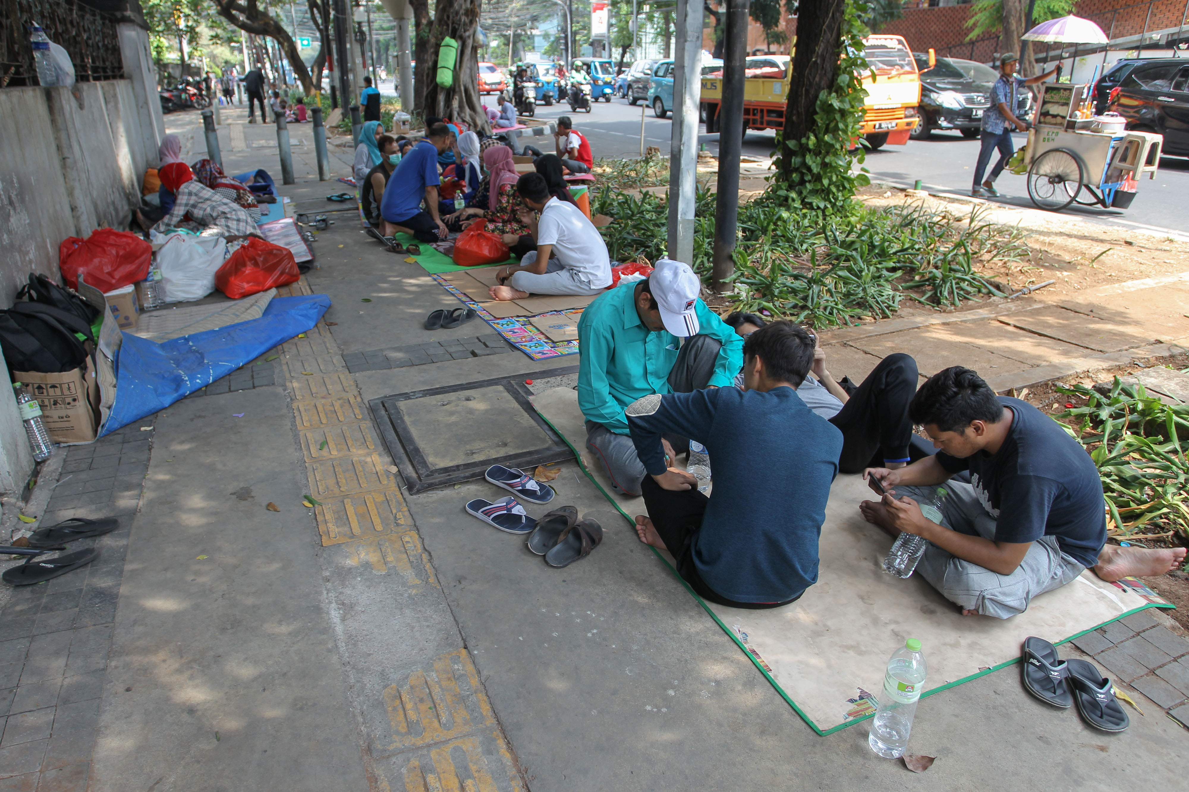 Para pencari suaka duduk di trotoar depan kantor UNHCR Jakarta