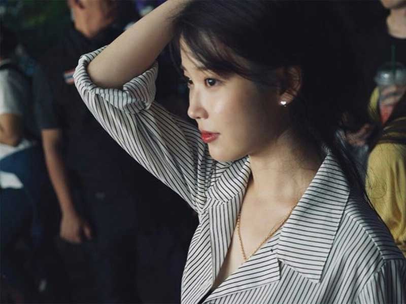 IU mengenakan kalung emas pemberian P.O