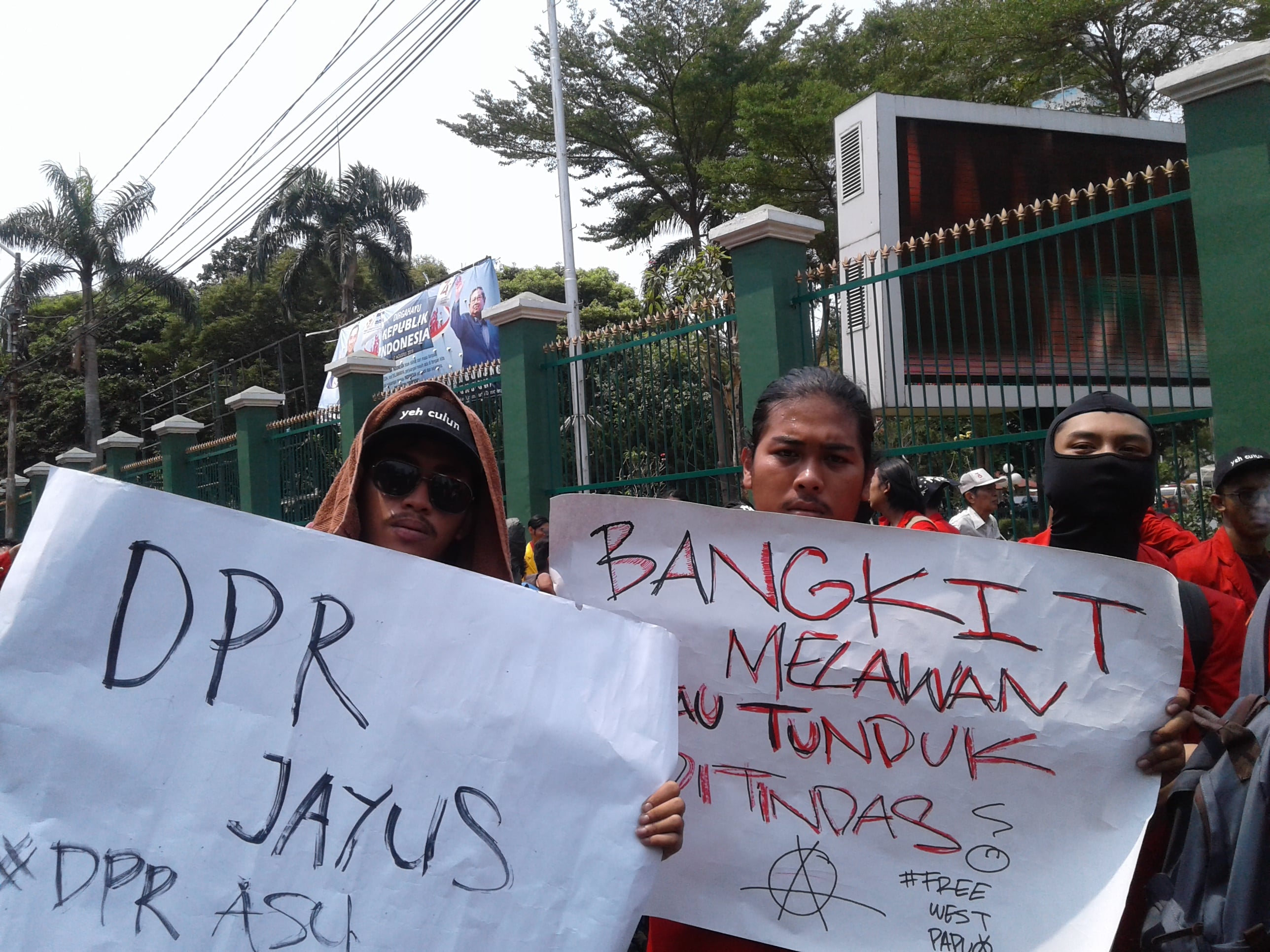 Seorang mahasiswa membentangkan poster saat demonstrasi menolak RUU KUHP di luar Komplek parlemen, Senayan, Jakarta.