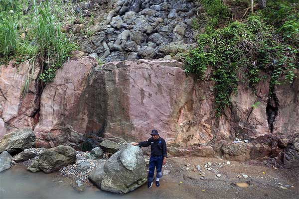 Seorang peneliti utama dari Lembaga Ilmu Pengetahuan Indonesia (LIPI) Chusni Ansori memperlihatkan batuan yang fenomenal di tebing Kali Munc