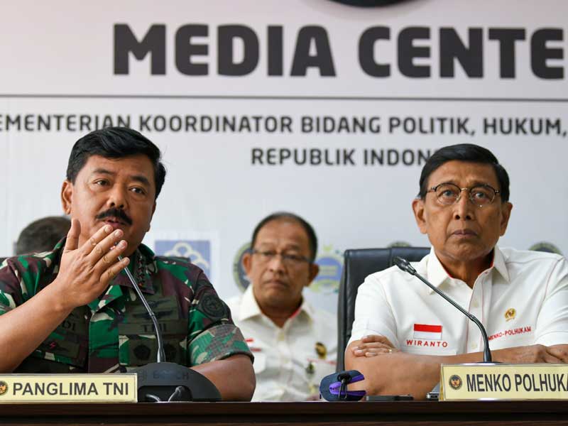 Menko Polhukam Wiranto (kanan) mendampingi Panglima TNI Marsekal Hadi Tjahjanto (kiri) memberikan keterangan pers di Kemenko Polhukam.