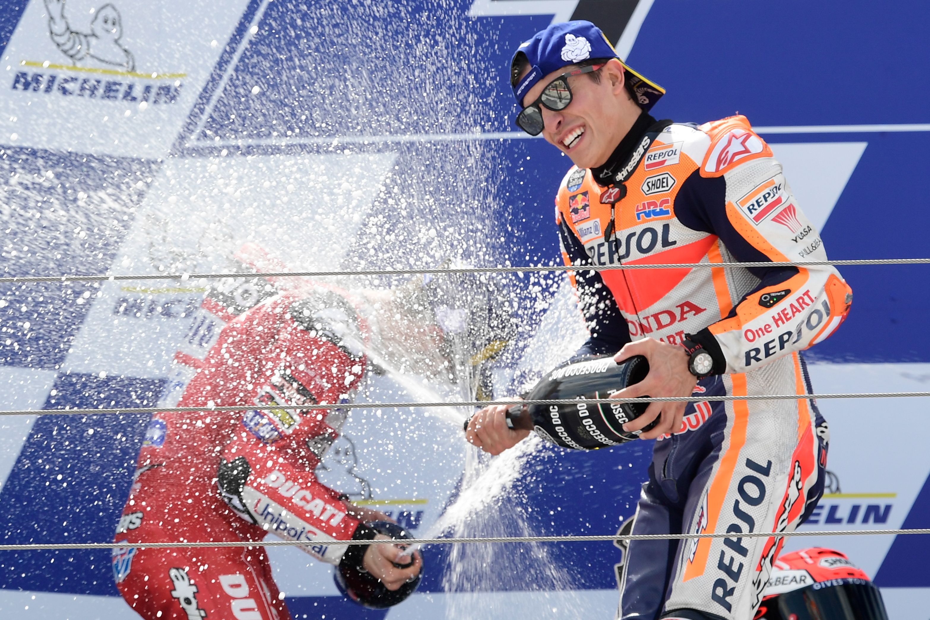 Pembalap Spanyol Repsol Honda Team Marc Marquez menyemprotkan sampanye ketika mereka merayakan kemenangan di podium di akhir balapan MotoGP 